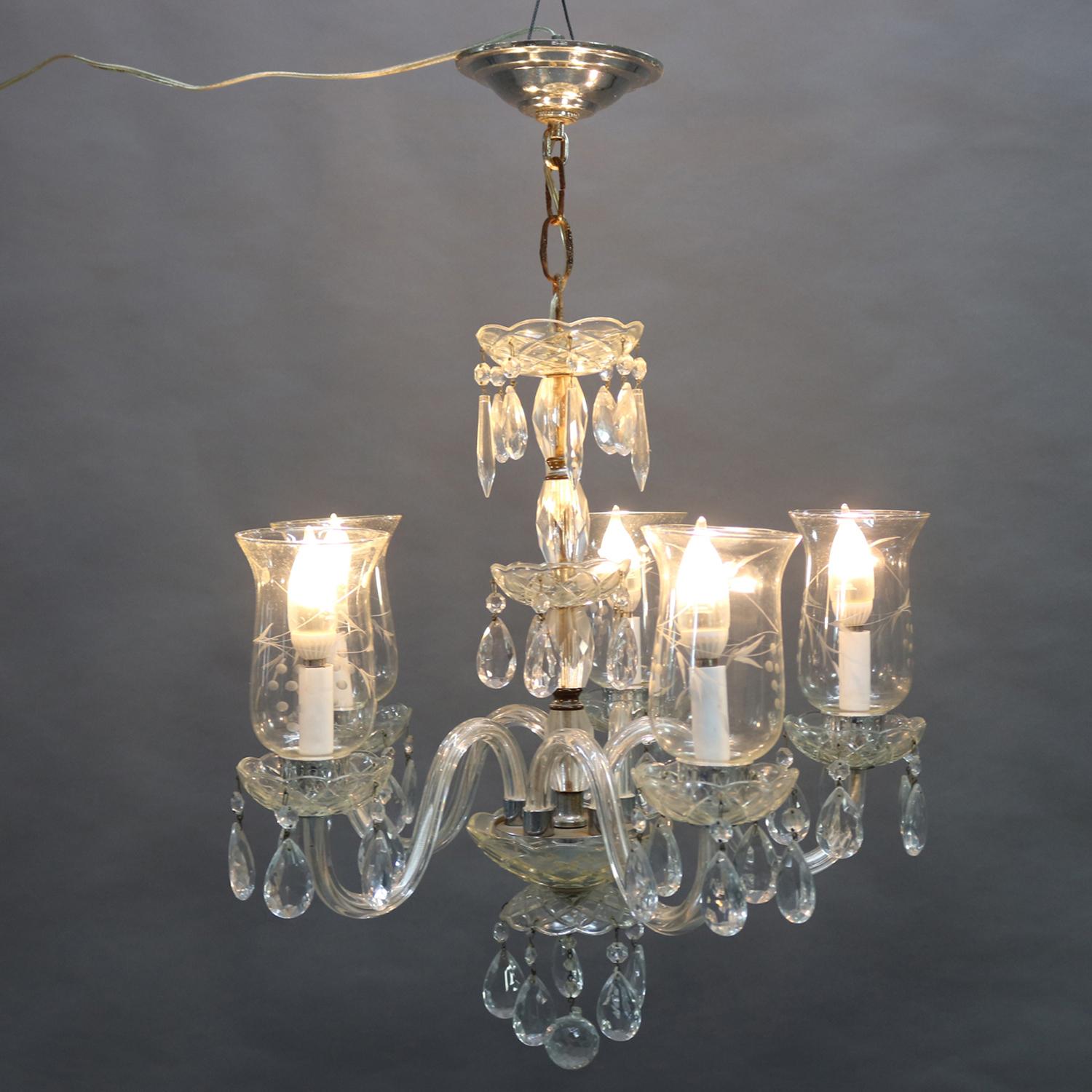 Vintage French chandelier features chrome frame with central crystal column having five s-scroll glass arms terminating in candle lights with cut-glass shades, rock and strung crystal highlights throughout, circa 1940.

***DELIVERY NOTICE – Due to