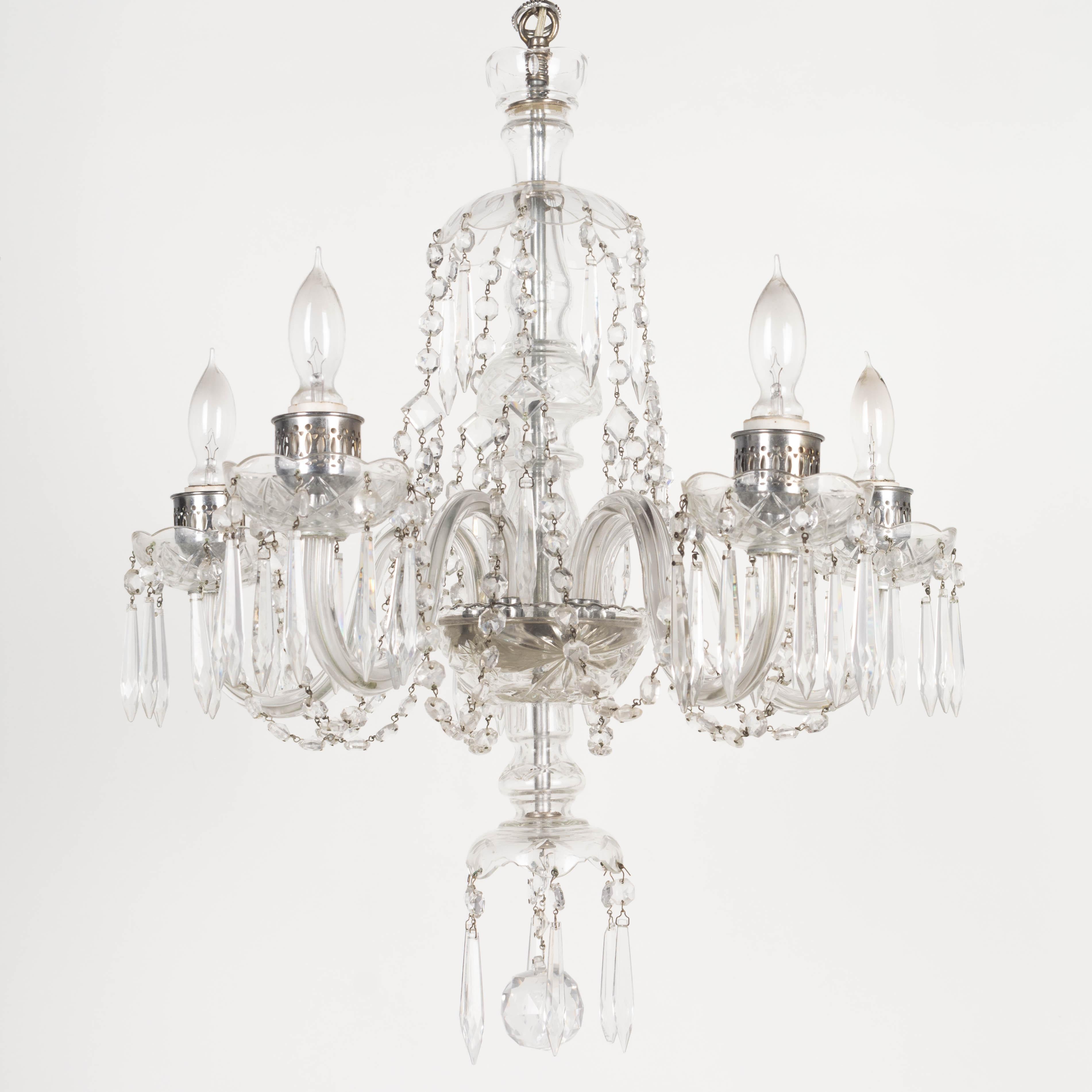 A vintage French five-light crystal chandelier with glass arms, cut glass bobeches and center column, hanging crystal prisms and faceted bead chain. In working condition. Circa 1970-1990. 24