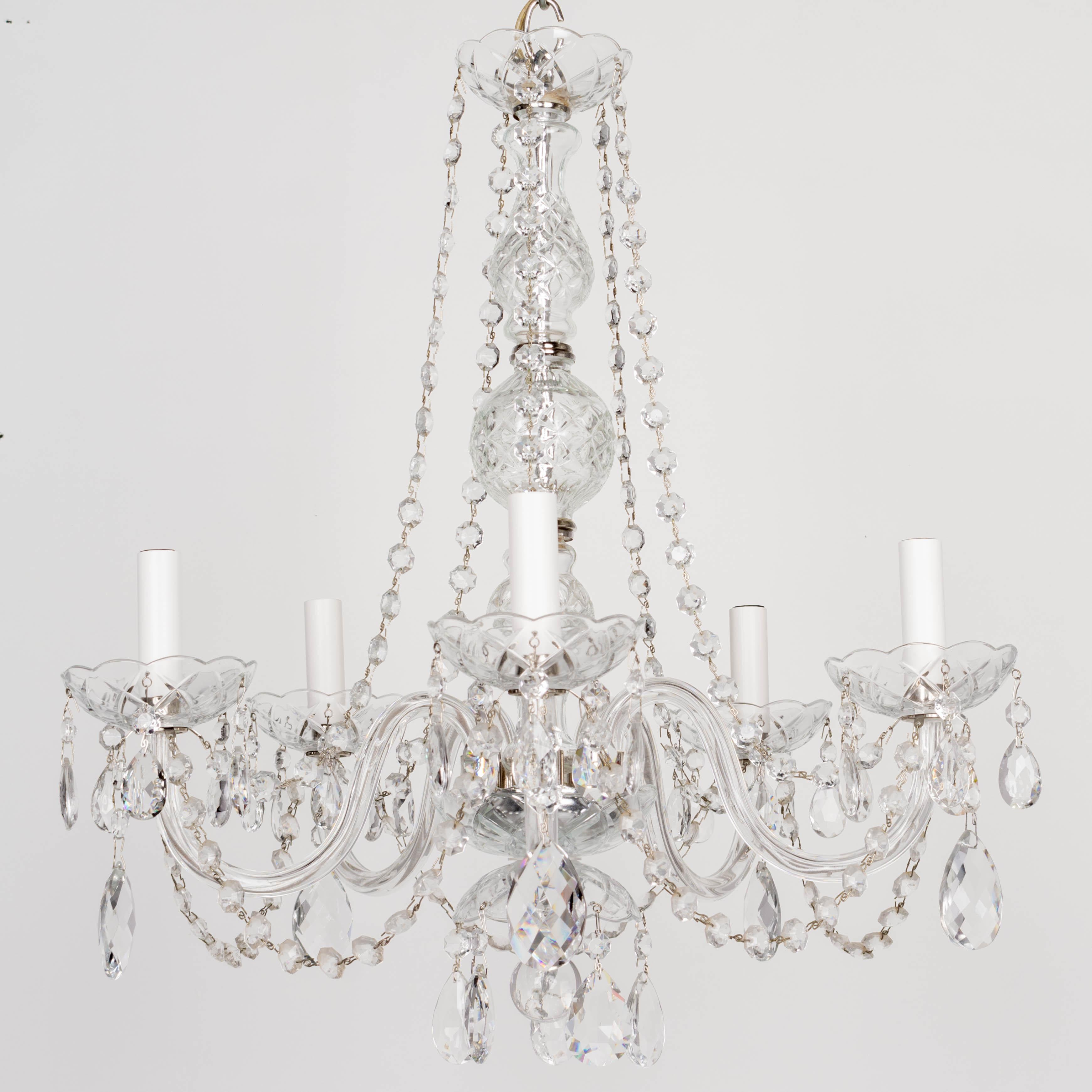 A vintage French five-light crystal chandelier with glass arms, cut glass bobeches and center column, hanging crystal prisms and faceted bead chain. In working condition. Circa 1970-1990. 22