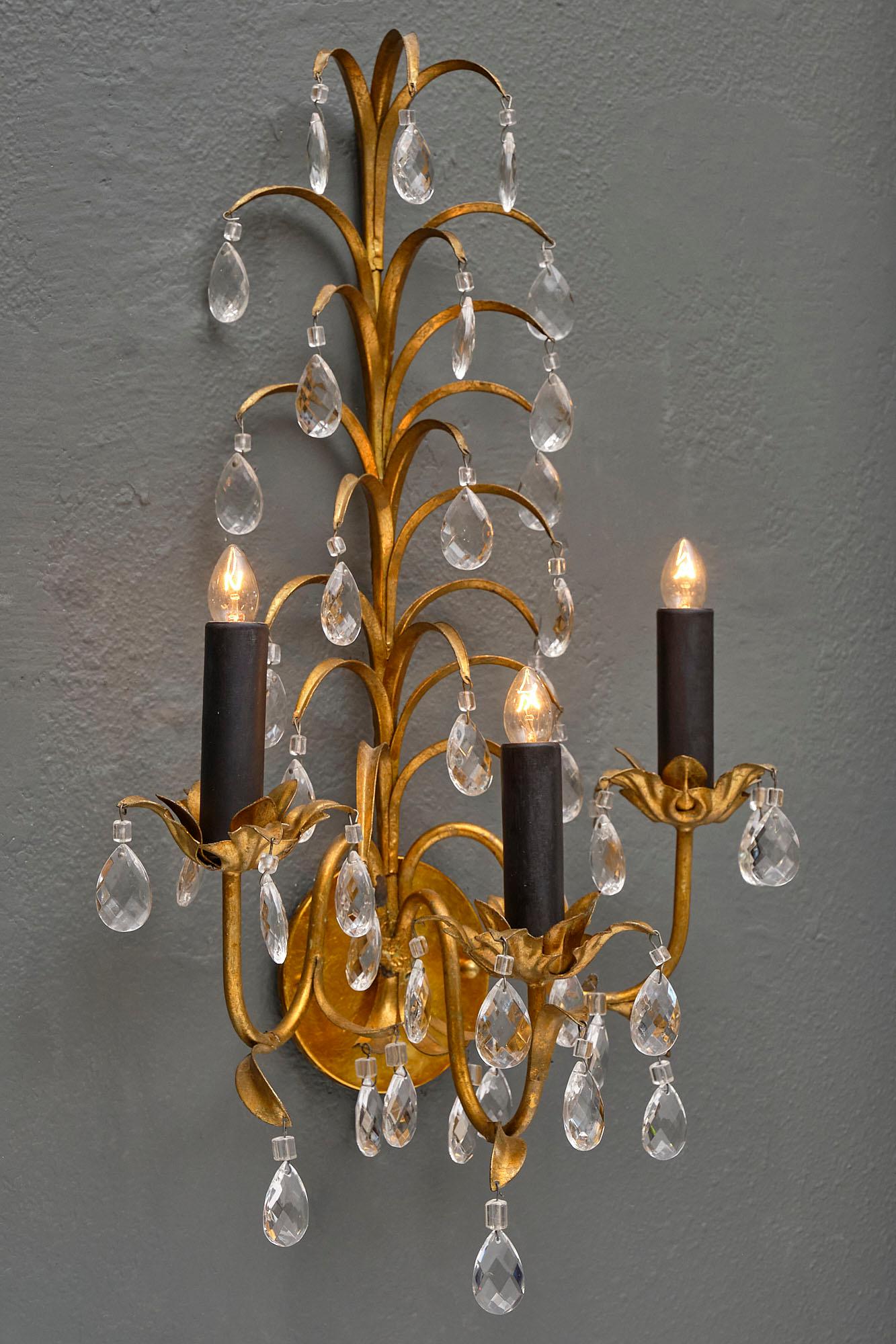 Pair of vintage French crystal sconces rewired to US standards. We love the cut crystal and gold leaf tole of this elegant pair.