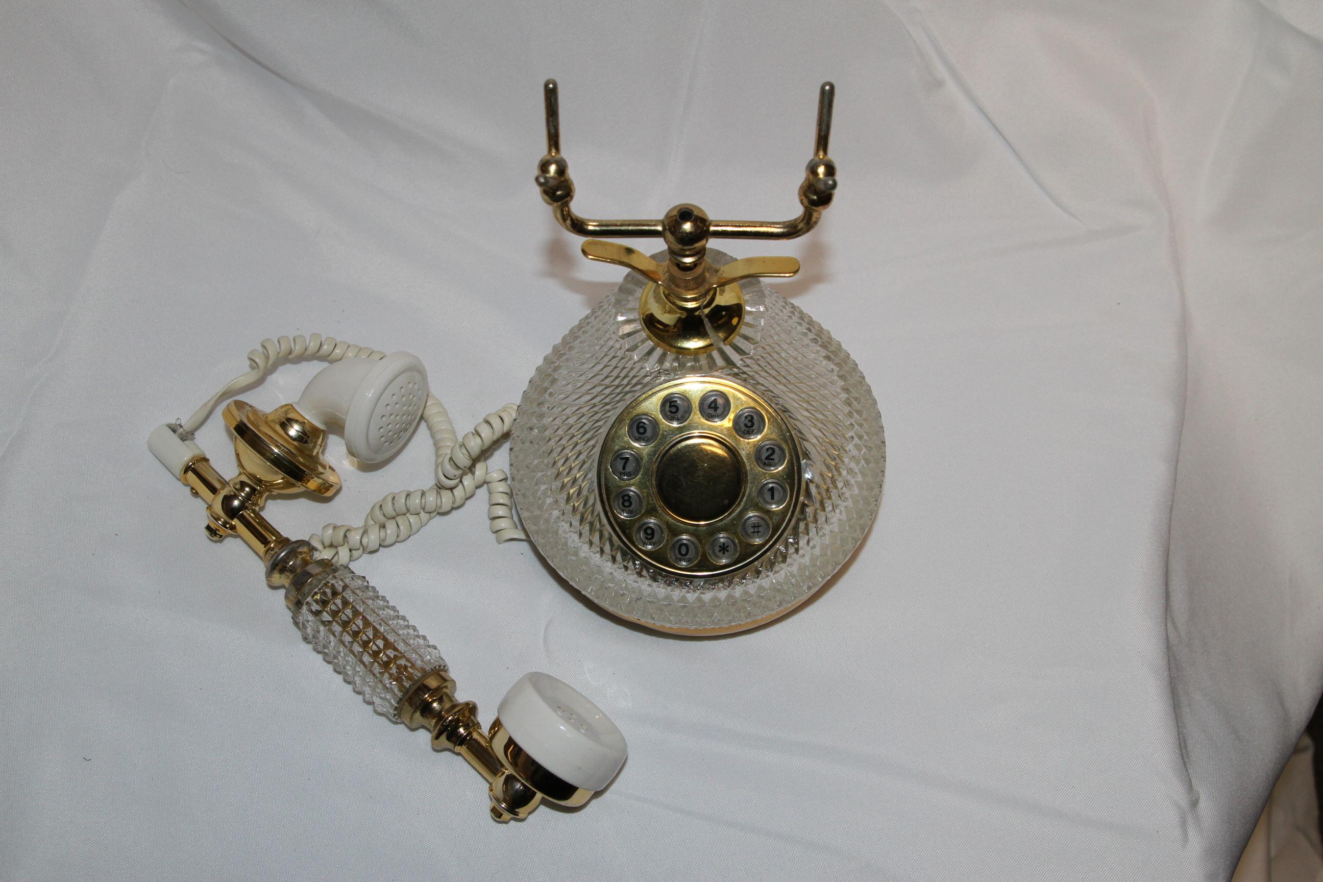 Este bonito teléfono está hecho de cristal y latón. Es una declaración histórica para tu casa. Un tema de conversación del pasado. El cristal está tallado y moldeado en la base y en el receptor. Los detalles de latón y los acentos acrílicos dan a