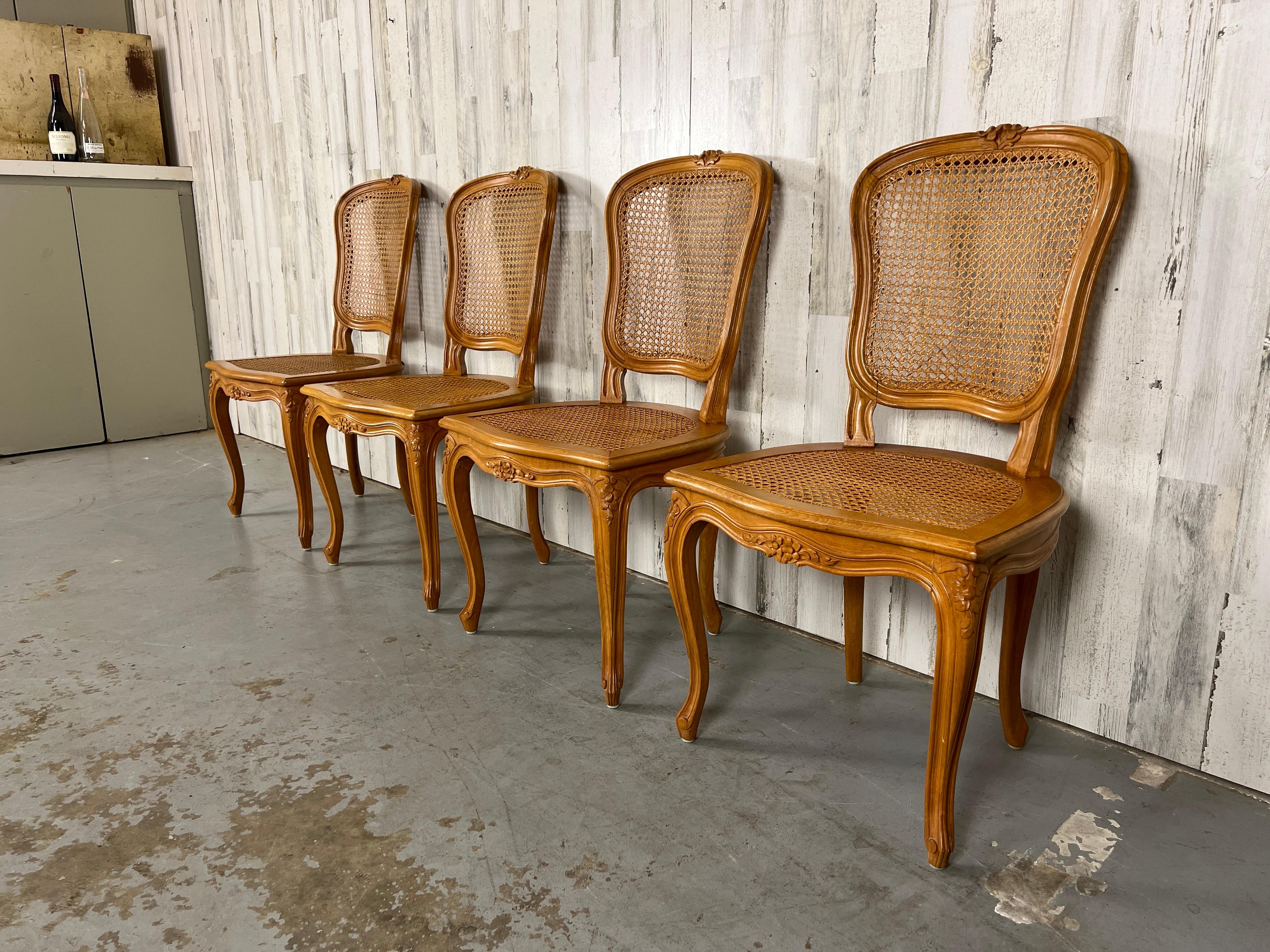 Set of Four beech wood cane chairs crafted in the style of Louis XIV. These chairs are very comfortable from the curved back and sturdy frames for hours of enjoyment.