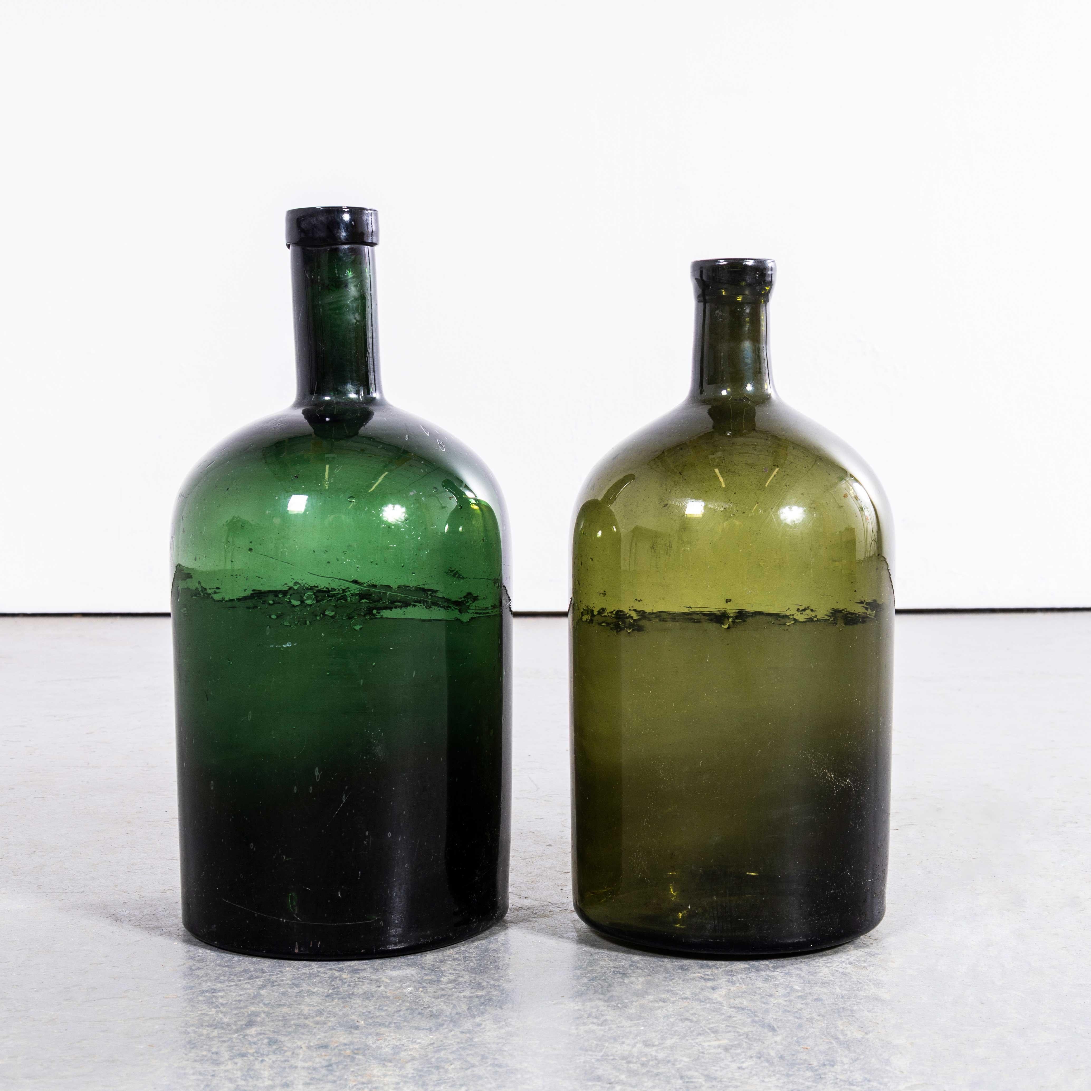 Damigiane francesi d'epoca in vetro verde scuro e smeraldo - Coppia. 

Una coppia di damigiane in vetro soffiato a bocca utilizzate come contenitori tradizionali principalmente per la conservazione e il trasporto del vino. Queste damigiane sono