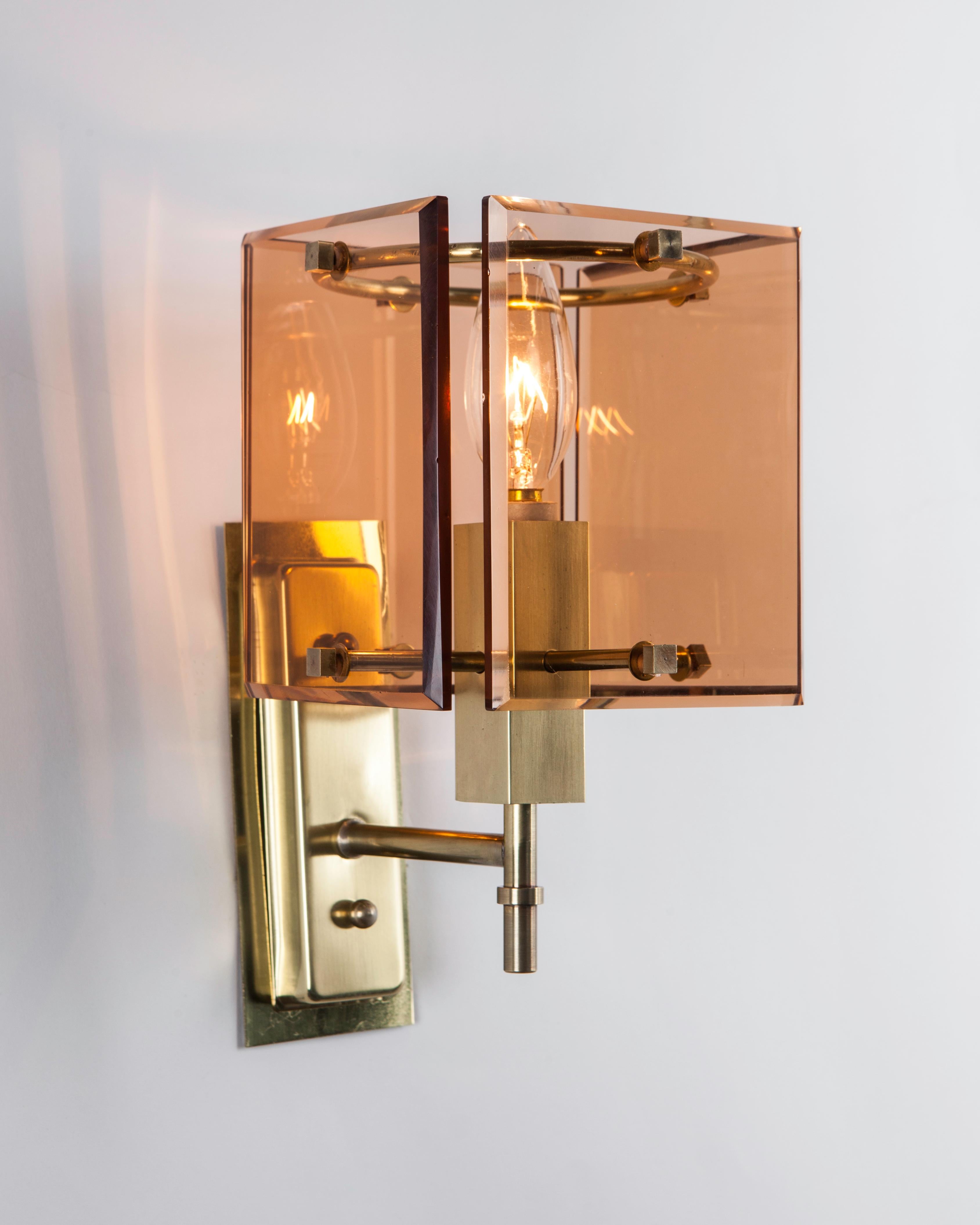 AIS3110
A pair of vintage French Deco sconces with square rose glass panel shades which create a wonderful warm glow. Small cube fasteners hold the glass onto rectangular brass frames in their original soft worn polished finish. Due to the antique