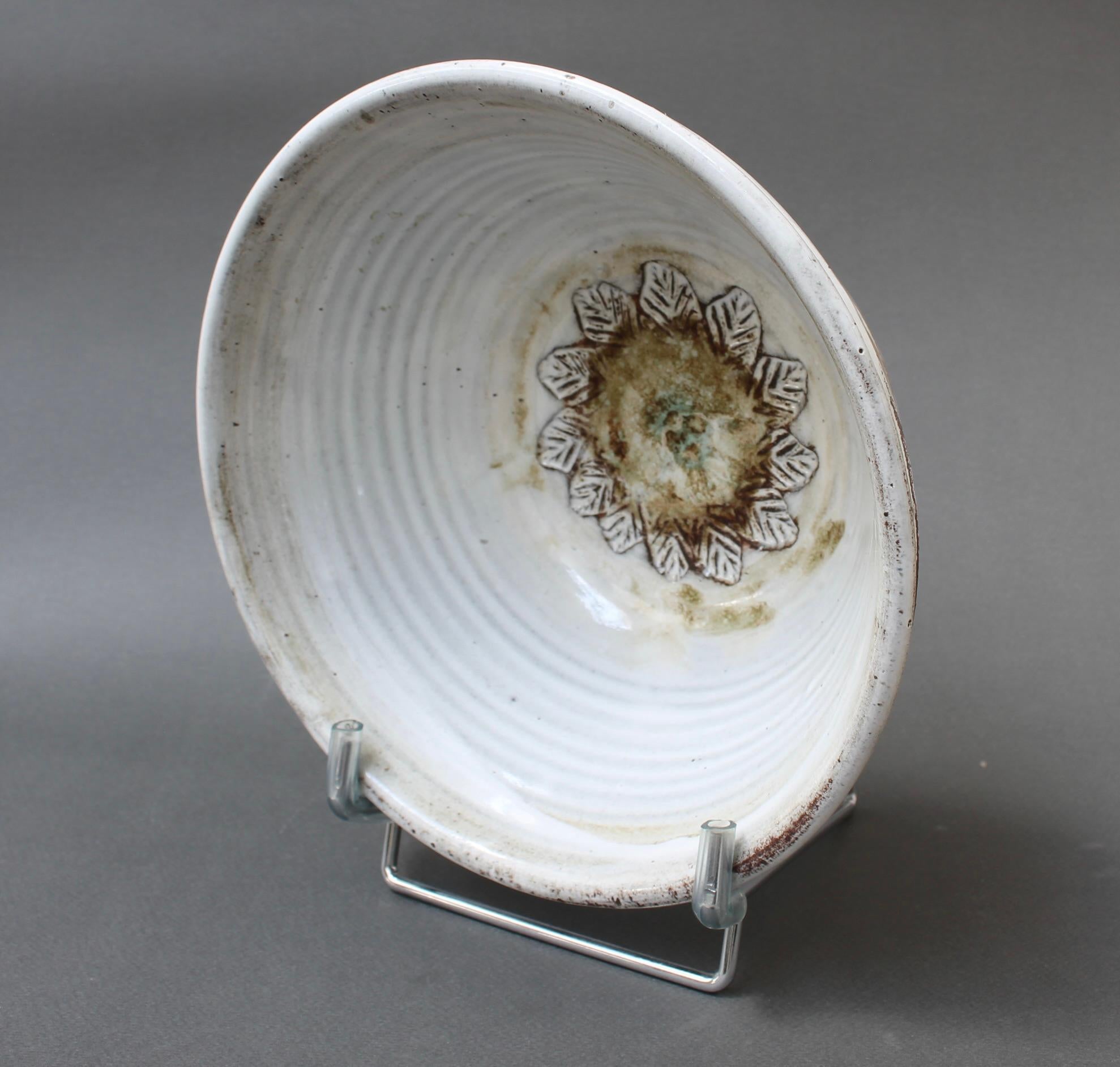 Mid-century French decorative ceramic bowl (circa 1960s) by Albert Thiry. Chalky-white glazed interior sides prepare the viewer for the delightful base which consists of a round of brown and green encircled by an incised leaf motif with a sunflower