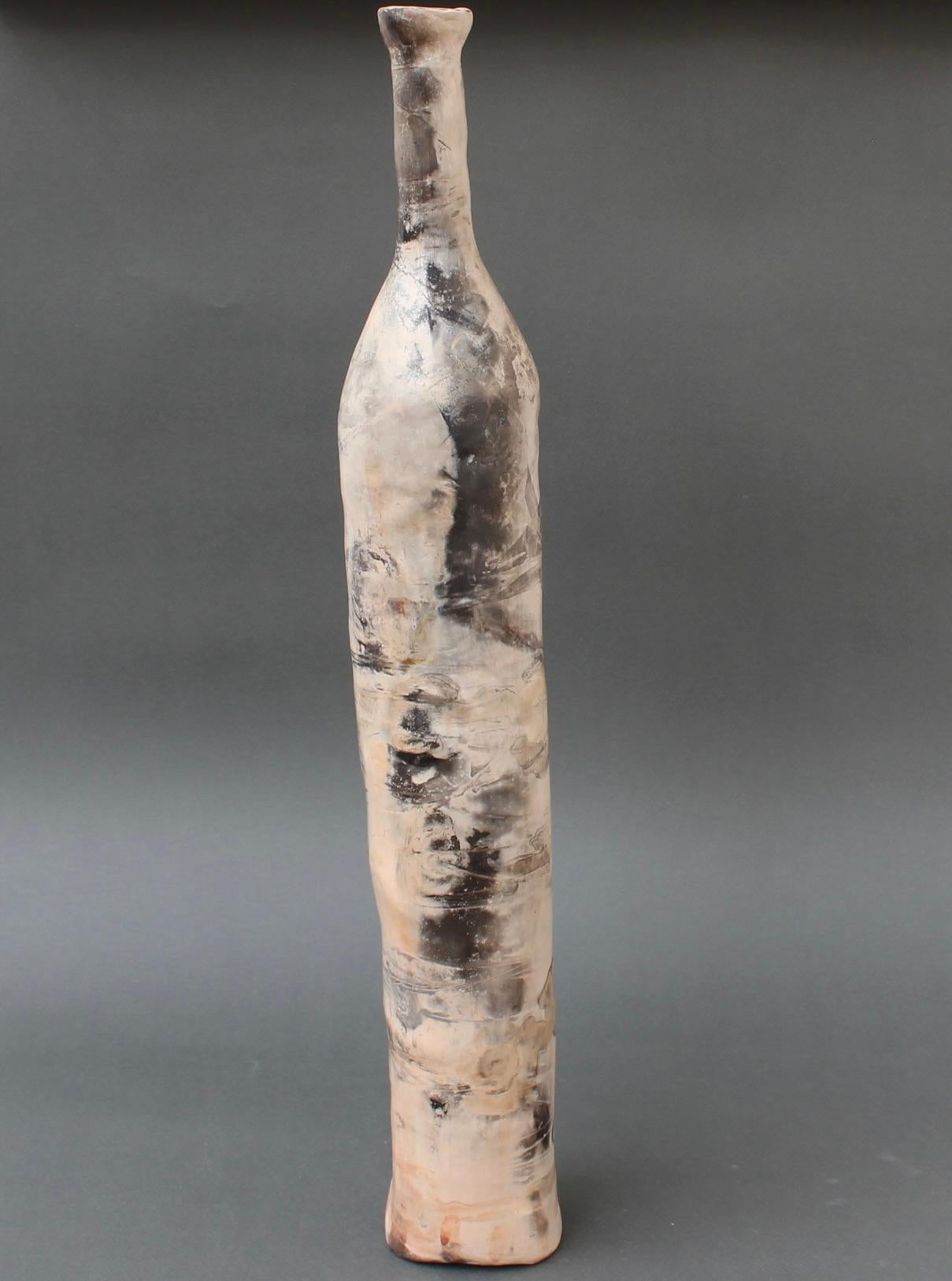 Vintage French decorative ceramic bottle (20th Century). Discovered in the city of Lyon, France, and stunning in every aspect, this extraordinary elongated bottle consists of a misty glaze with a dusty coral colour punctuated with flesh tones and