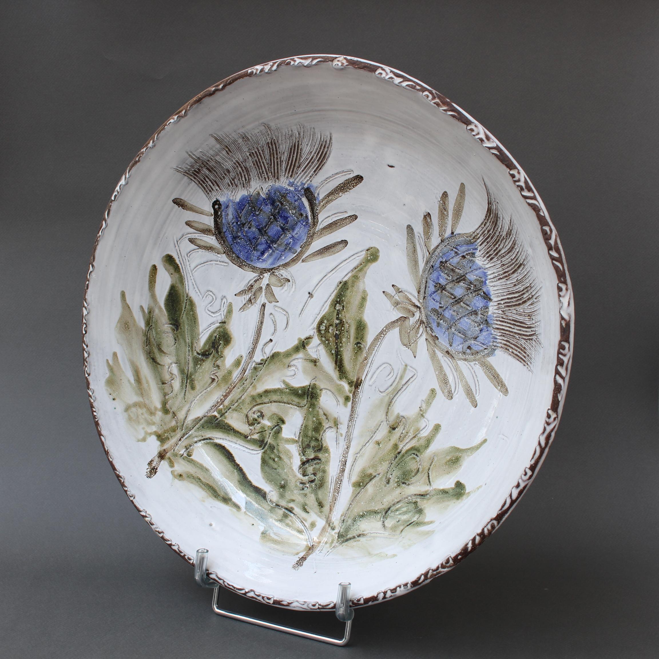 Large mid-century decorative platter (circa 1970s) by Albert Thiry. A creamy-white glaze with touches of blue-grey provides the background for a colourful thistle motif in the centre recess. The rim is an earthy brown with incised shapes in white.