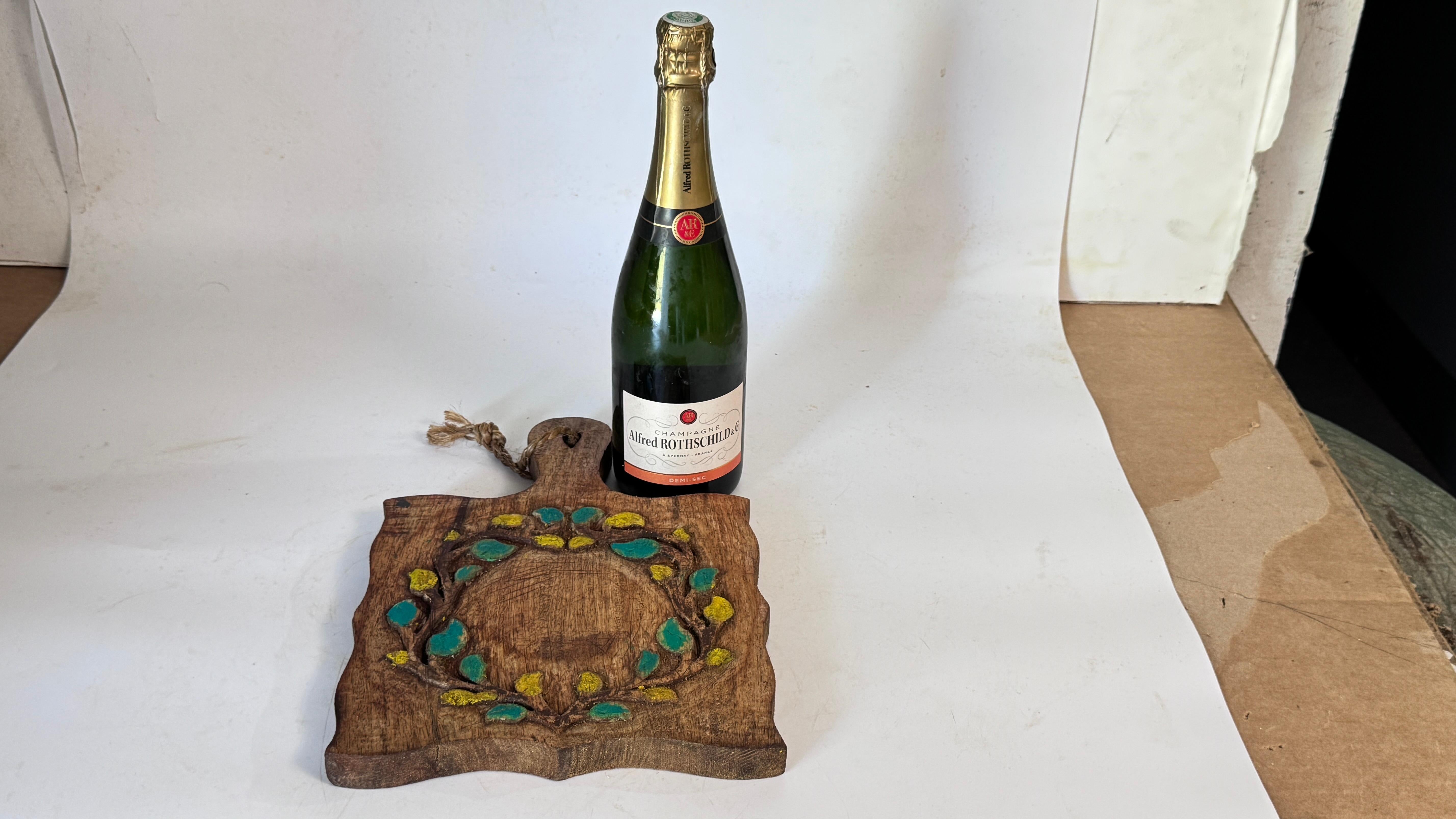 Si tratta di una tavola di legno francese vintage degli anni '60, con un motivo floreale dipinto a mano. L'arredamento comprende rami e fiori nei toni del giallo e del verde, che spiccano sullo sfondo marrone caldo del Wood. La tavola non è
