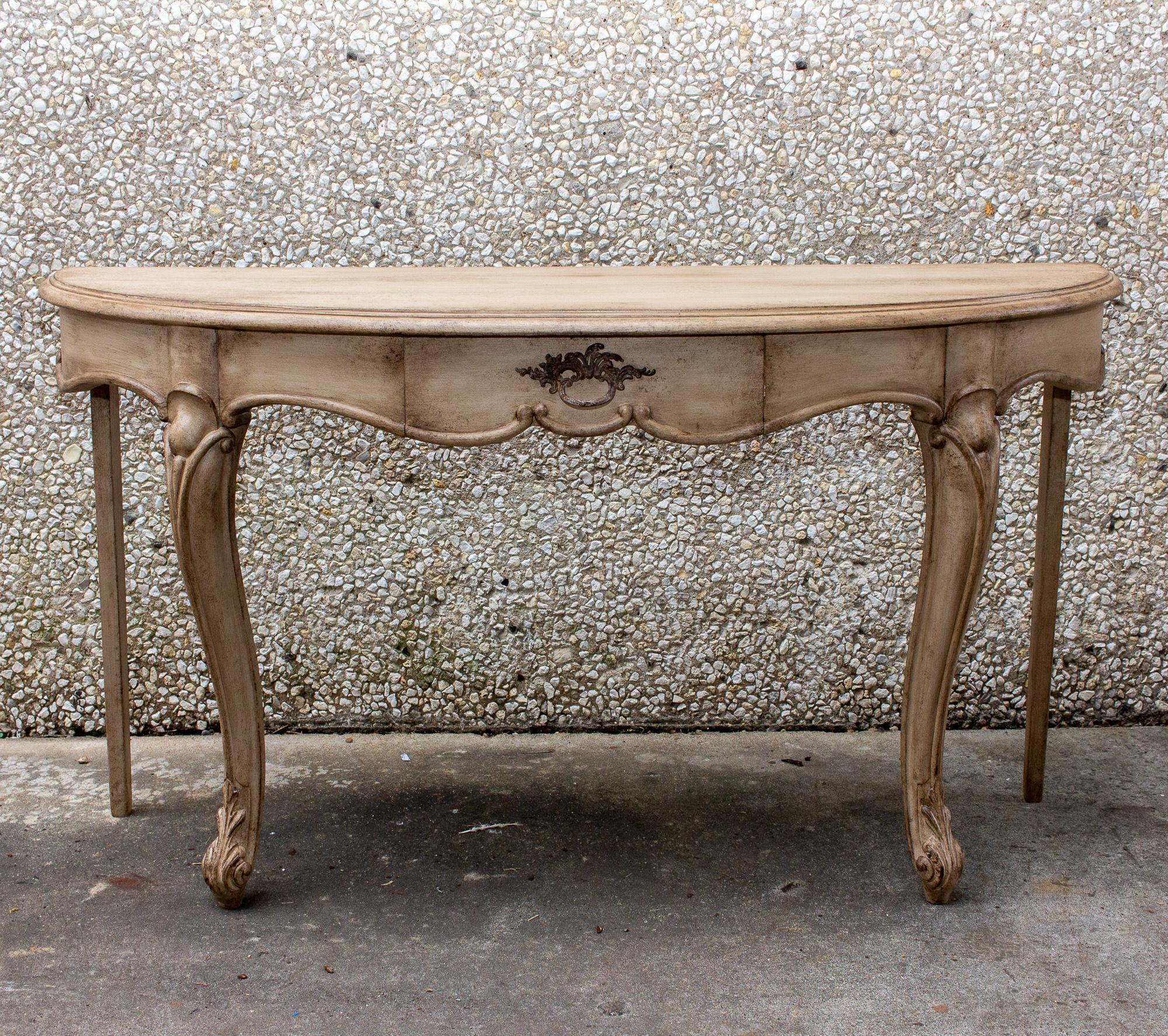 Vintage French oak demi lune console table with carved detail and brass hardware. Lovely and functional piece with classic lines recently discovered in Europe and we particularly like the neutral patina and coloring. Sliding middle drawer provides