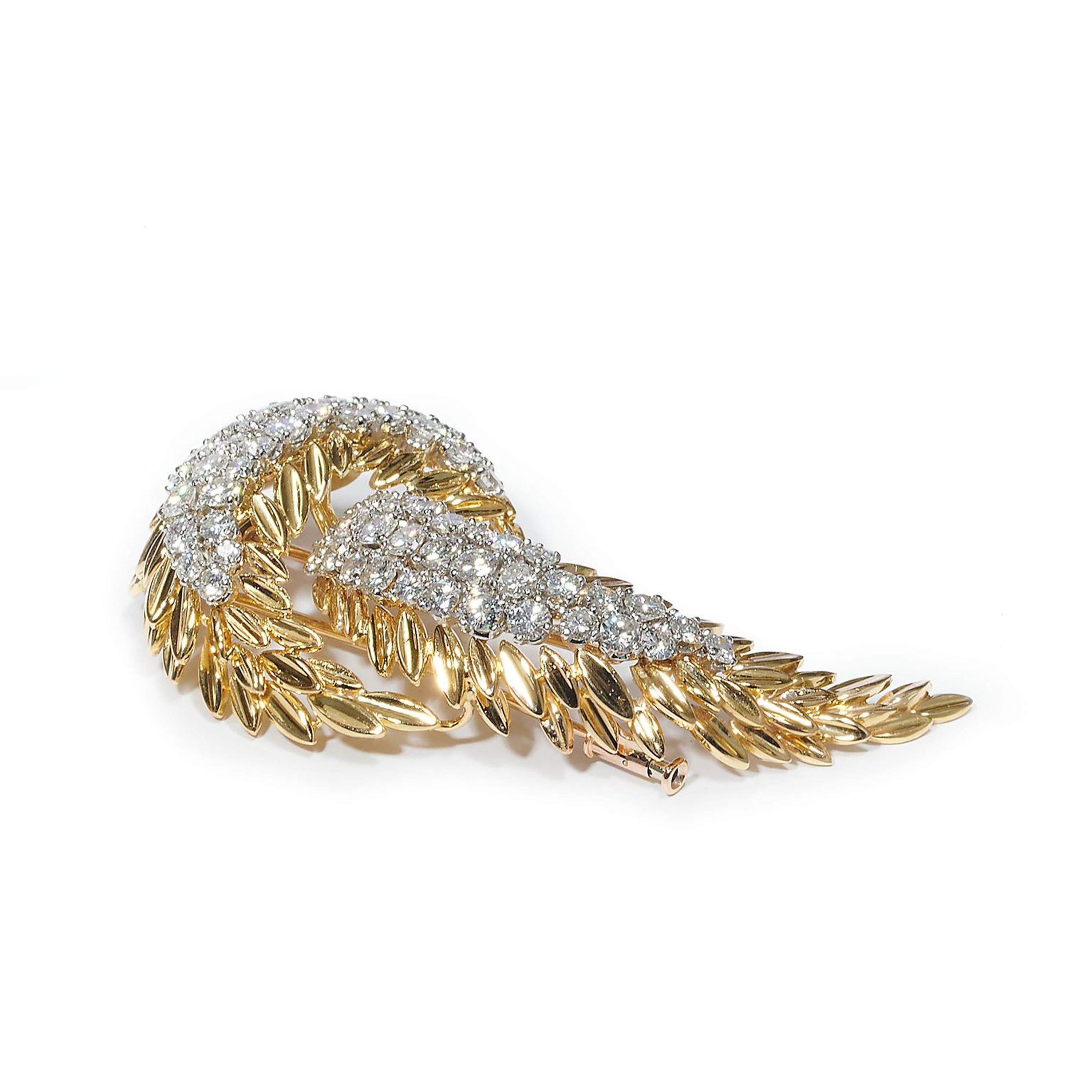 A vintage, French, diamond and gold abstract feather or palm leaf and fruit brooch, set with two clusters of round brilliant-cut diamonds, with an estimated total weight of 5.95 carats, in white gold, four claw settings, surrounded by polished,