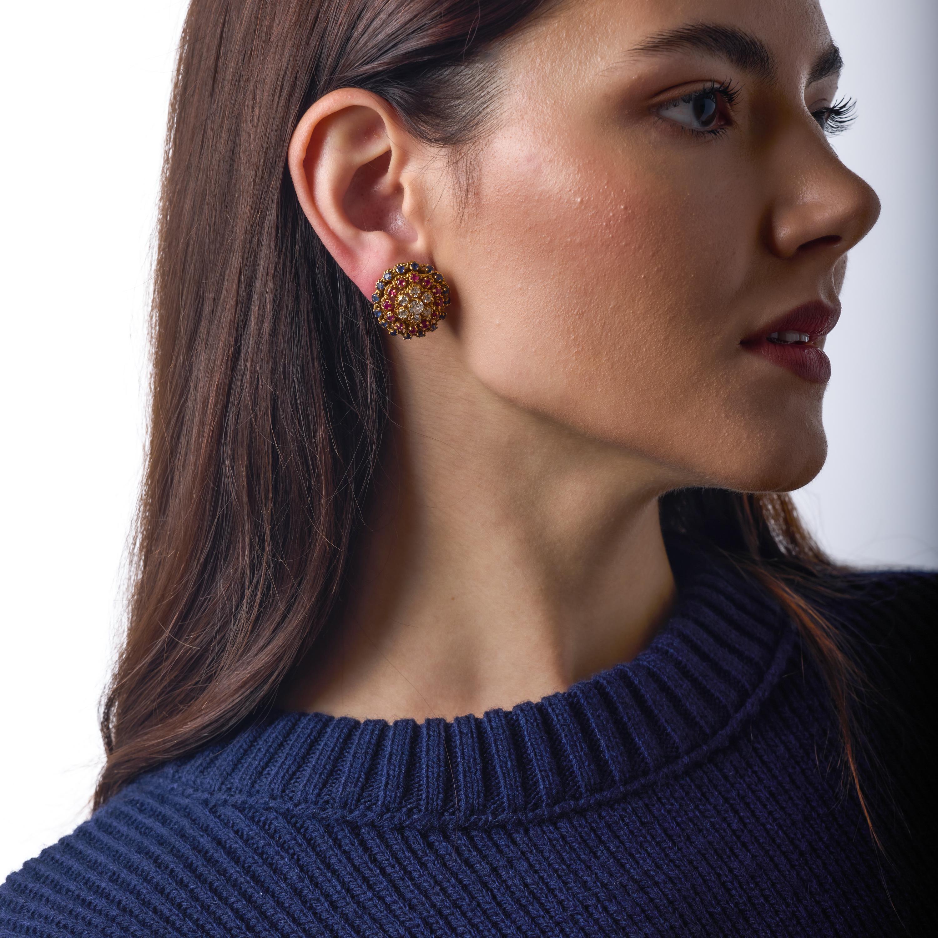 Diese exquisiten französischen Ohrringe zum Anstecken entfalten eine lebhafte Farbsymphonie aus leuchtend blauen Saphiren, üppigen Rubinen und schimmernden Diamanten in einem kühnen, skulpturalen Design. Ihre gesättigten Edelsteine leuchten warm auf