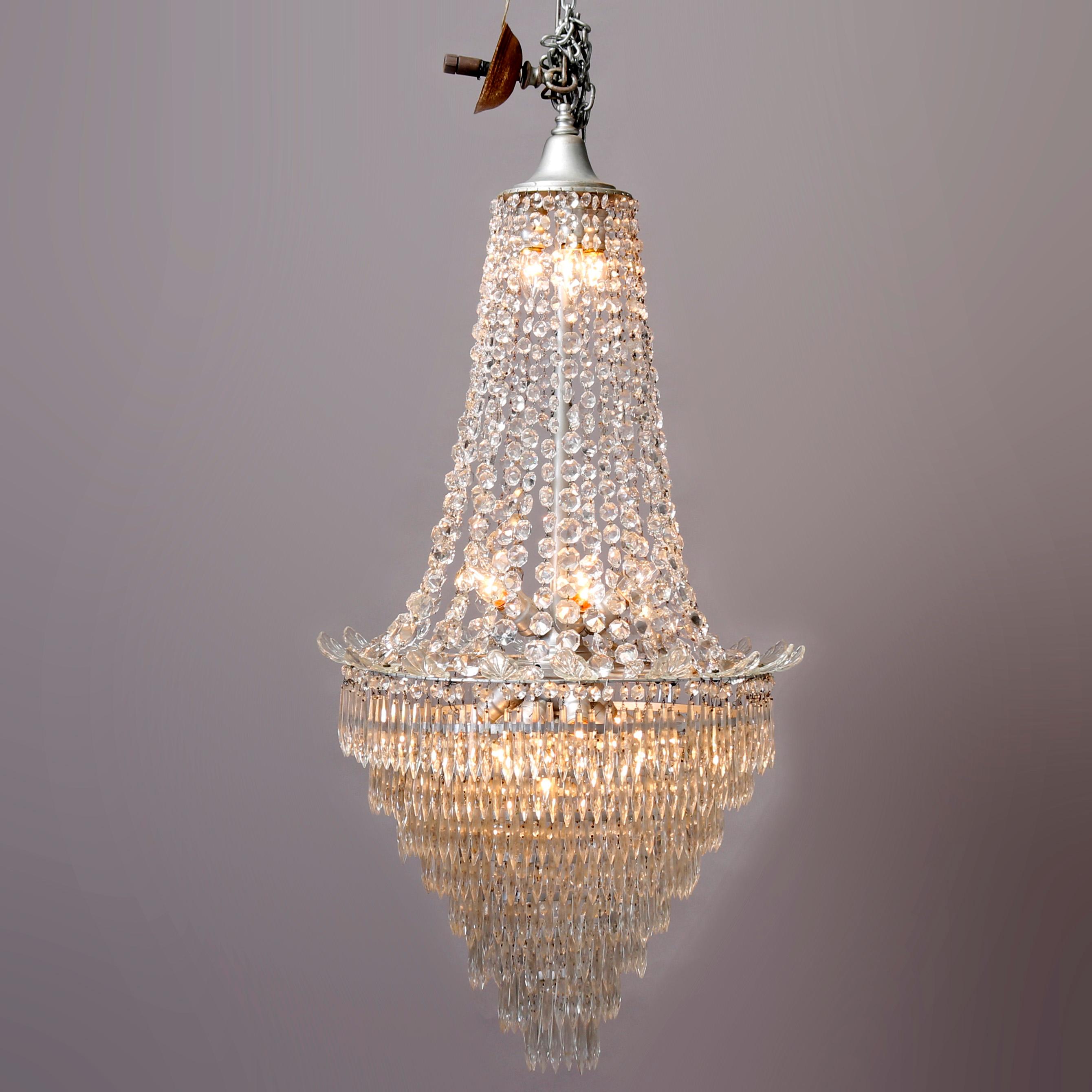 A vintage French chandelier offers tiered wedding cake form with fifteen lights having draped strung and drop cut crystals throughout, 20th century.

Measures: 53