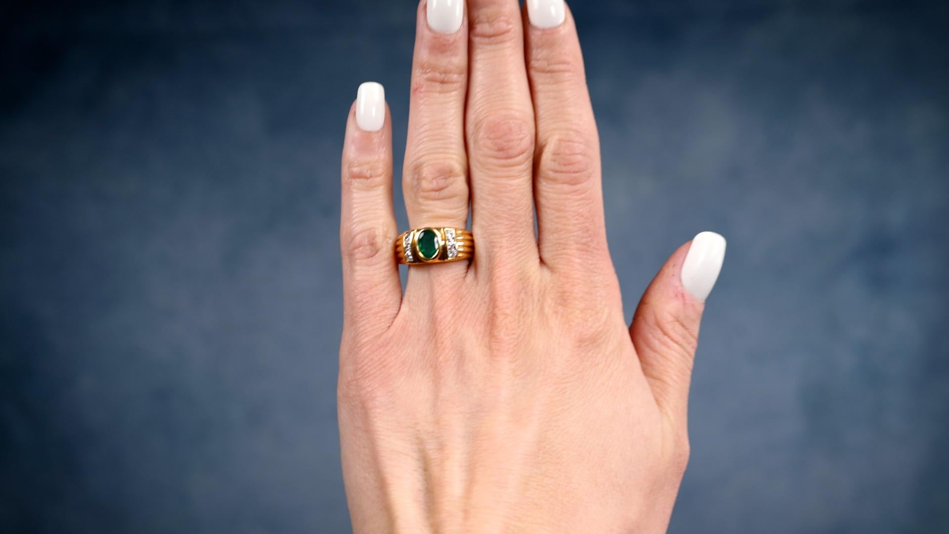 One Vintage French Emerald and Diamond 18k Yellow Gold Ring. Featuring one oval mixed cut emerald weighing approximately 0.65 carat. Accented by six round brilliant cut diamonds with a total weight of approximately 0.30 carat, graded G-H color, SI