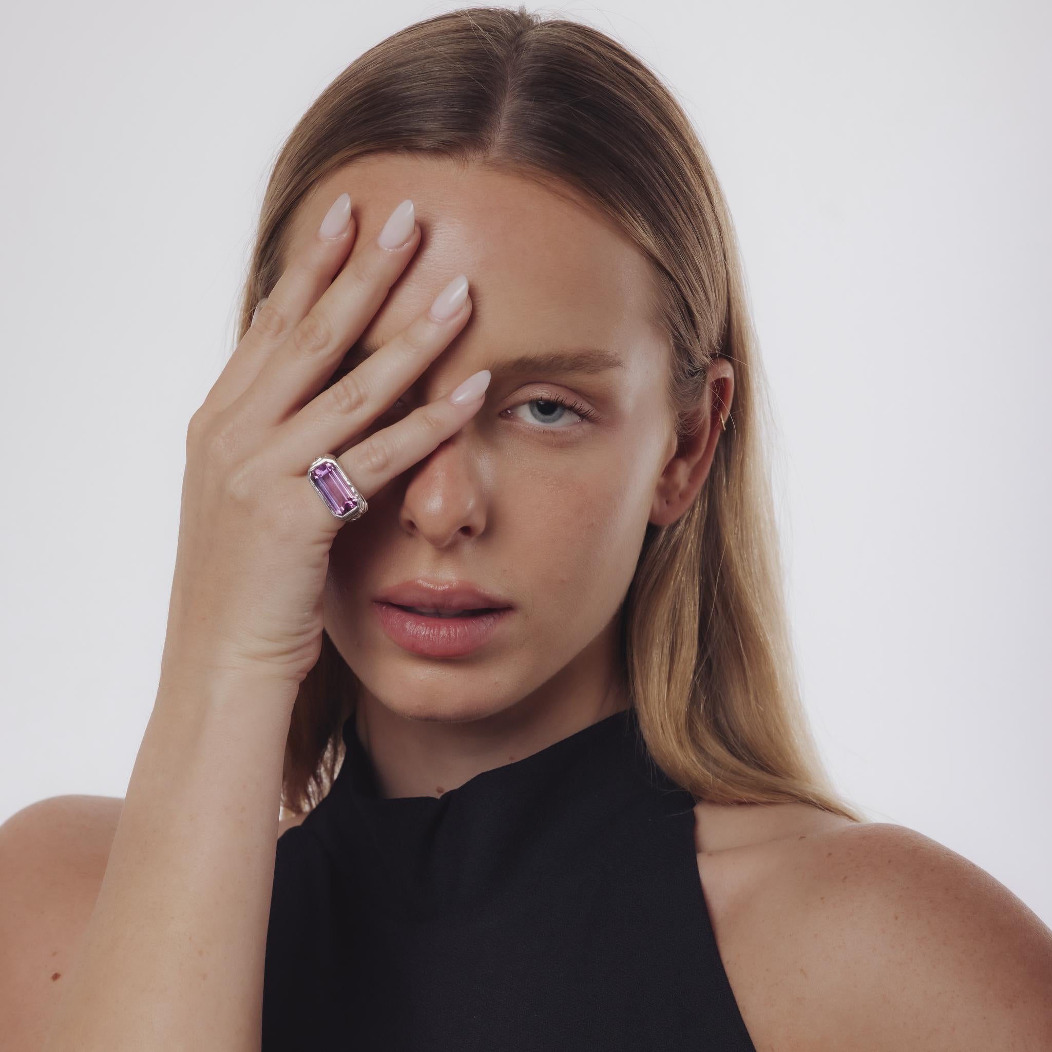 Dieser französische Vintage-Ring aus den 1980er Jahren strahlt eine kühne Eleganz aus, in deren Mittelpunkt ein 7,40 Karat schwerer Amethyst im Smaragdschliff steht, der durch seine Präsenz besticht. Der lebendige Edelstein wird von sechs runden