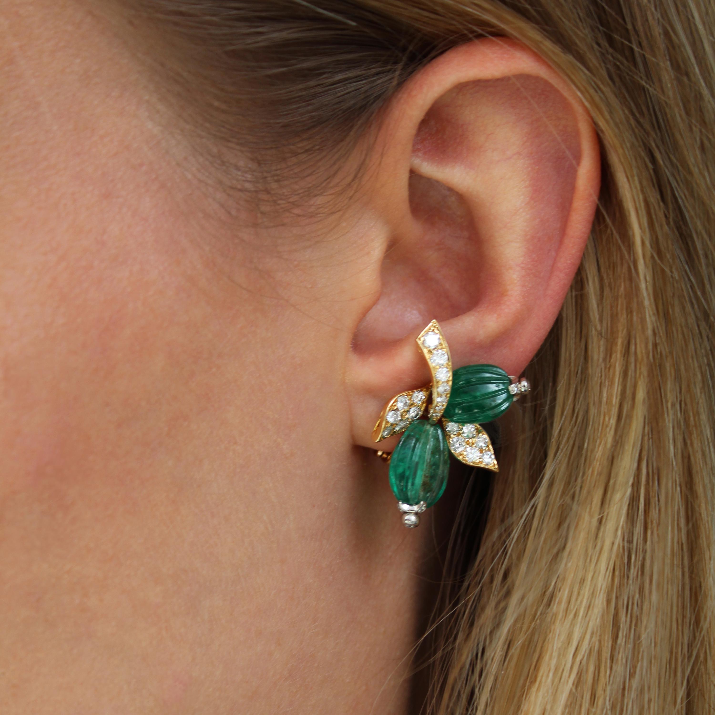 A pair of French, vintage emerald, diamond and gold earrings by André Vassort, each set with two watermelon cut emeralds, on the form of berries, with diamond set terminals, with two leaves and a stalk pavé set with round brilliant cut diamonds,