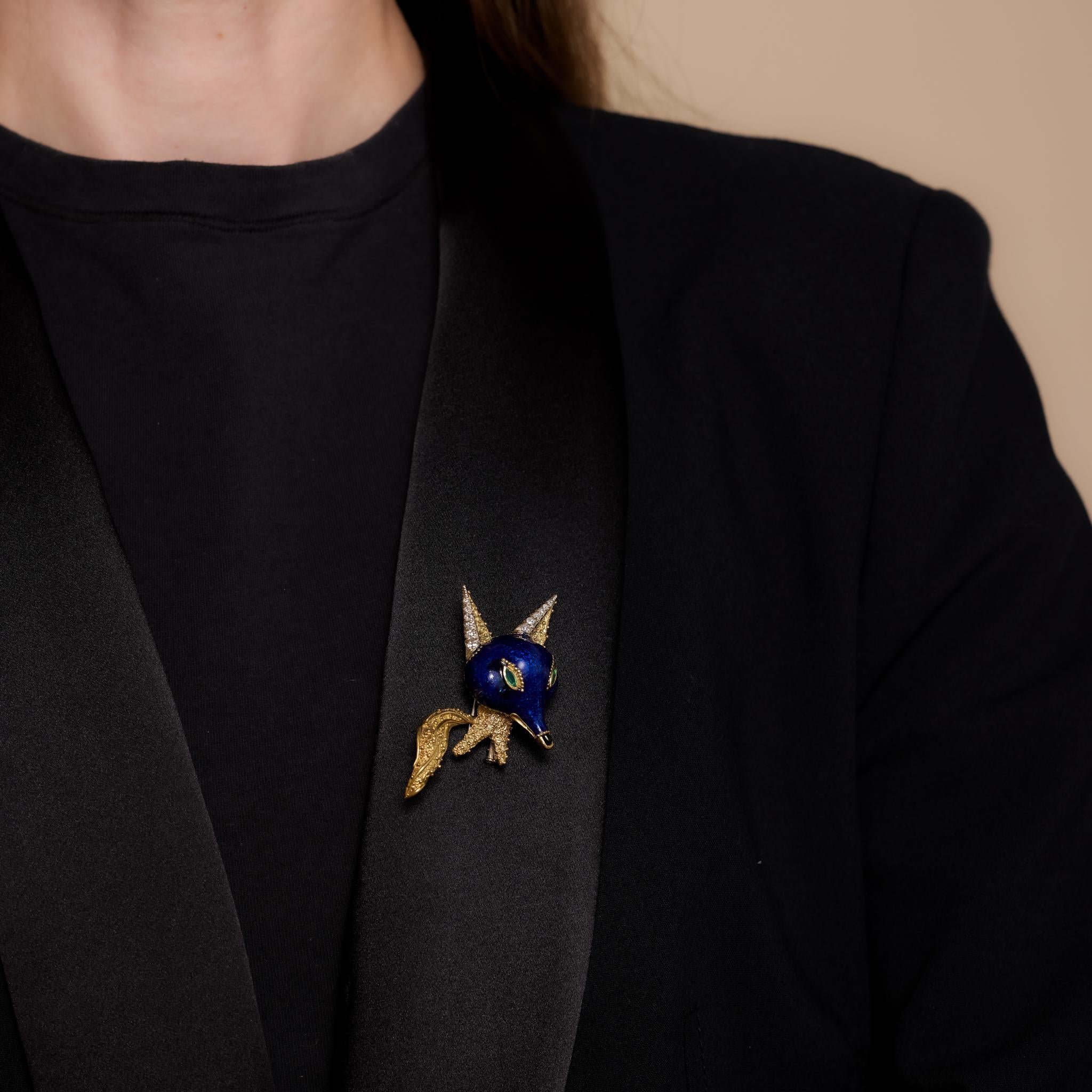 This vintage French enamel fox brooch showcases two marquise cut emeralds totaling .12 carats, 12 single cut diamonds weighing .30 carats (G color, VS clarity), and onyx details. Crafted in 18k yellow gold with enamel, it bears the French eagle head