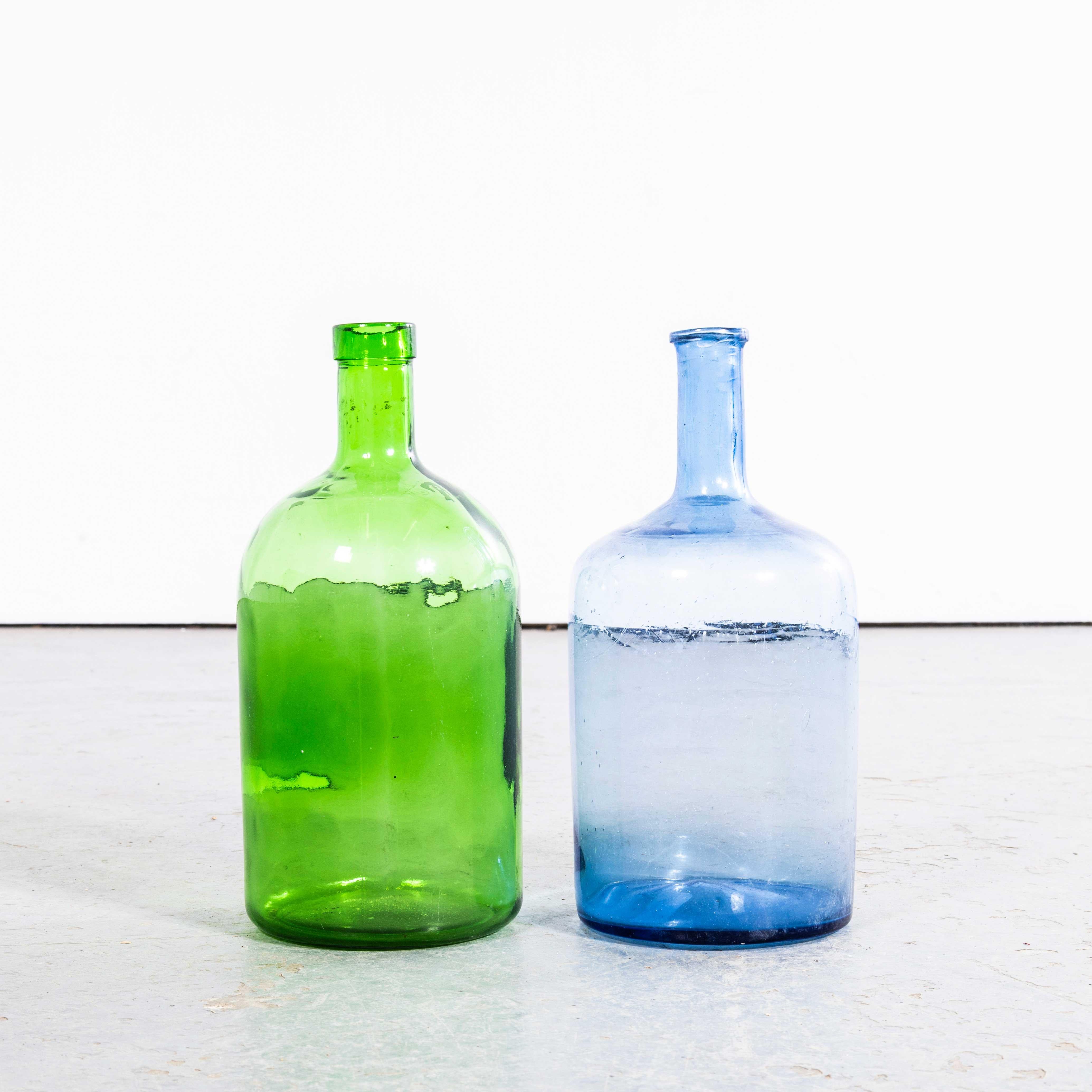 Damigiane francesi d'epoca in vetro verde smeraldo e blu cobalto - Coppia. 

Una coppia di damigiane in vetro soffiato a bocca utilizzate come contenitori tradizionali principalmente per la conservazione e il trasporto del vino. Queste damigiane