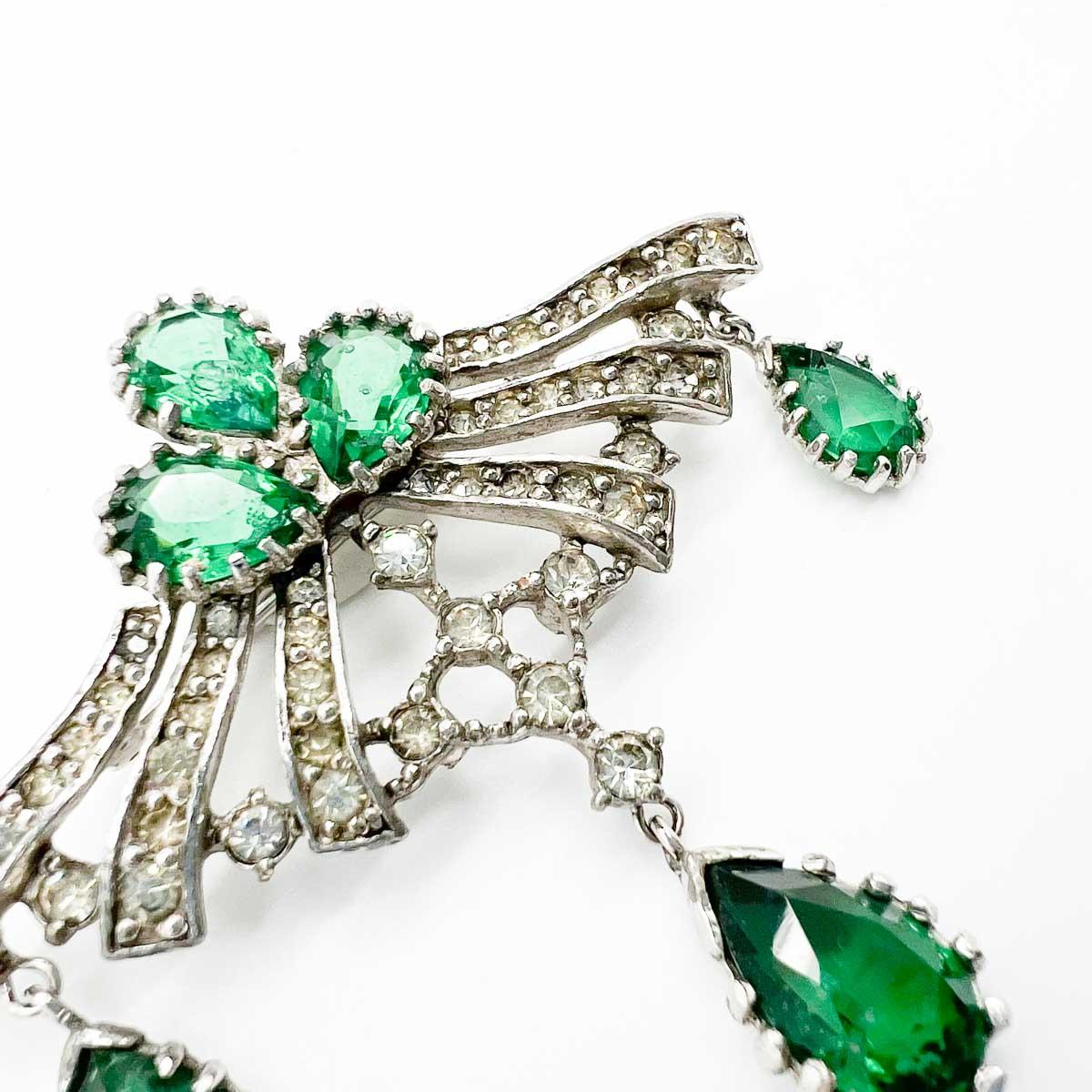A delightful Vintage French Emerald Paste Brooch. Whilst unsigned nor attributed this piece carries elements of couture pieces. Not least the exquisite attention to detail in the setting including individually and finely claw set stones, the flawed