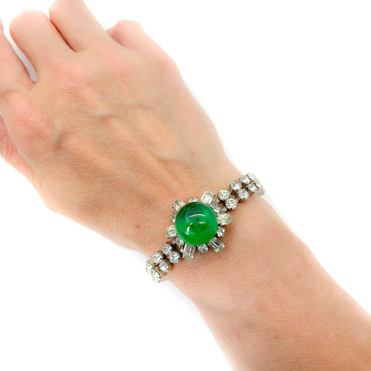 An alluring Vintage French Emerald Glass Bracelet. Featuring a large, poured glass cabochon stone central to a starburst inspired central panel. A timeless beauty originating from a magical time for bijoux jewellery in France.
An unsigned beauty. A
