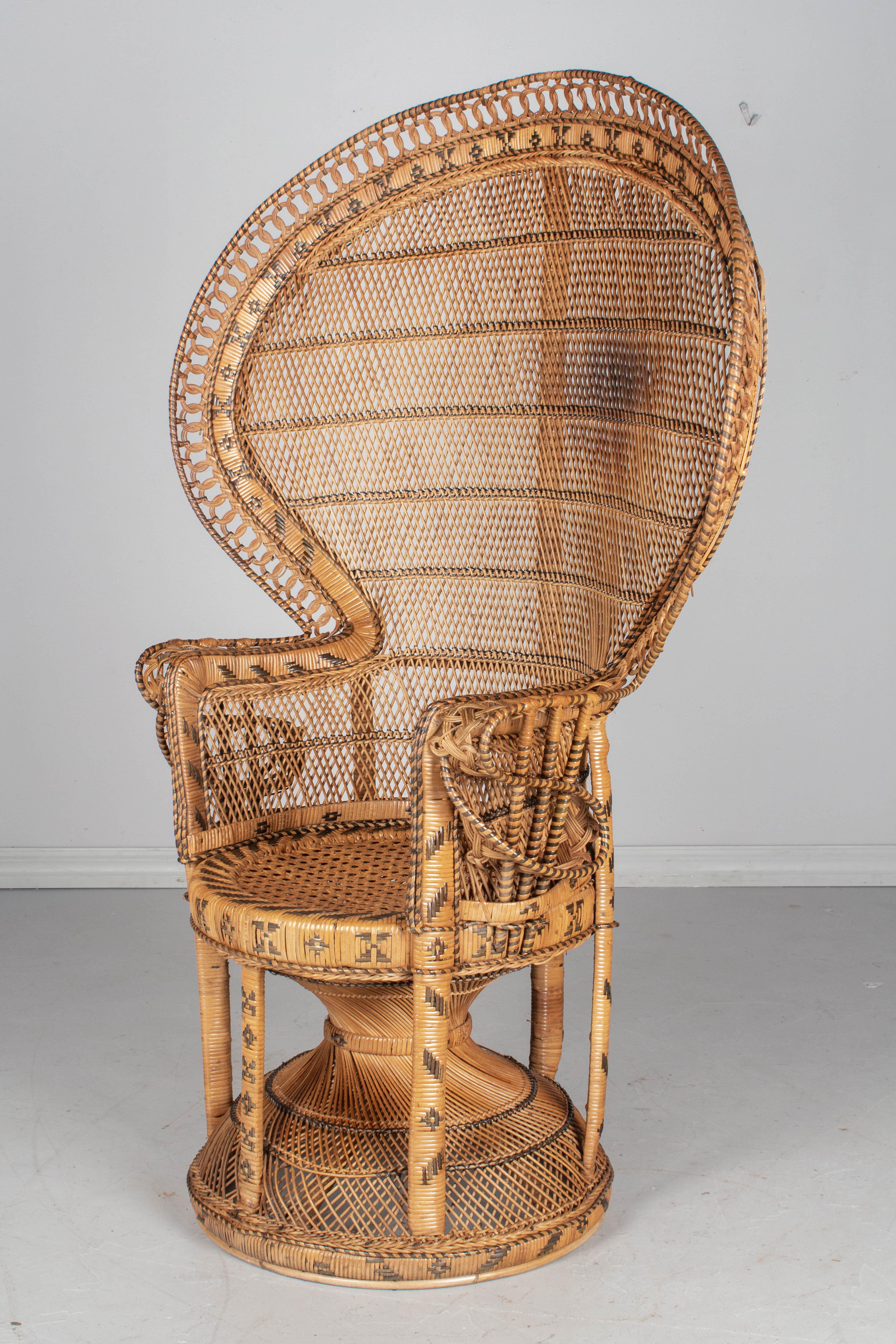 A vintage French peacock armchair, with full fan back, made of handwoven rattan and produced by the French company Kok Maison in the 1970s. A stunning boho chic statement piece, beautifully crafted with intricate detailing, especially in the curved