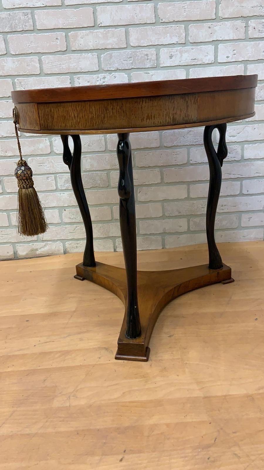 This Vintage French Empire Biedermeier Style Inlaid Parquet Sunburst Round Side/Entry Table is a stunning piece. Featuring carved swans adorning each leg, this table showcases a unique sunburst inlay design. Ideal for use as a side or end table, or