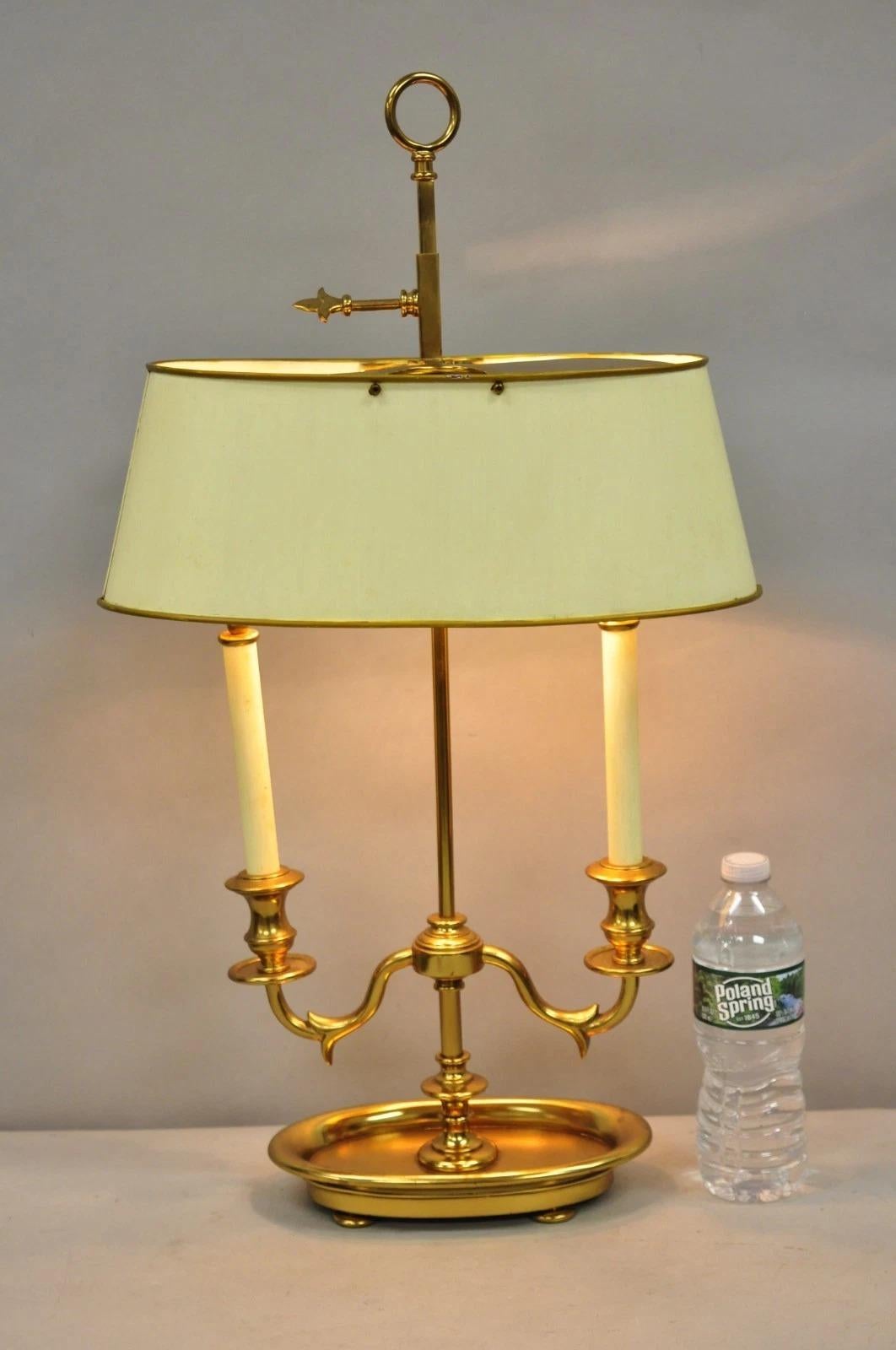 Lampada da tavolo Bouillotte a due candelabri in stile impero francese, in ottone e metallo, con paralume ovale regolabile in metallo verniciato bianco. Circa alla fine del XX secolo. Misure: 26