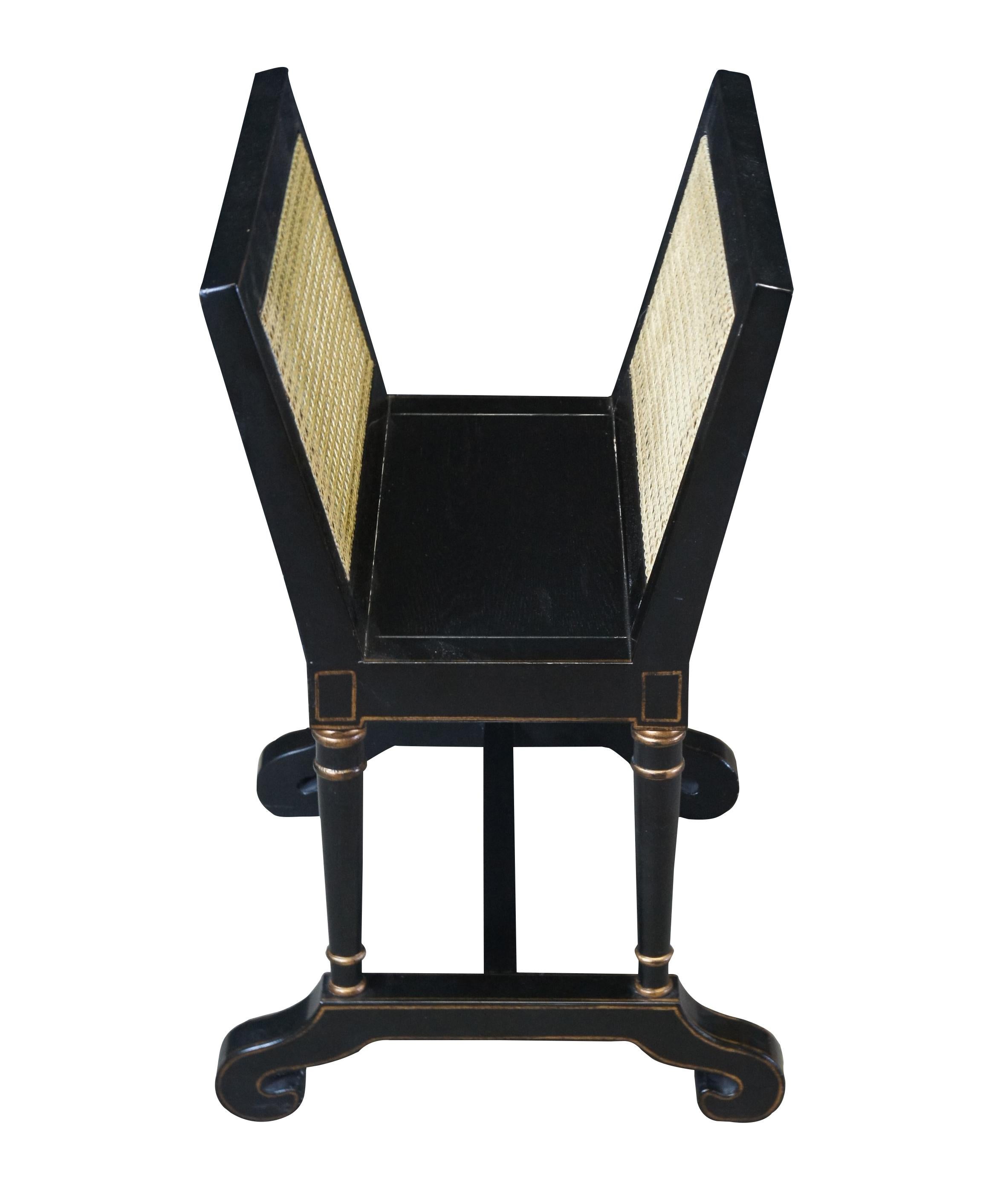 French Empire Napoleon III style ebonized magazine rack. Made from oak with flared caned magazine or newspaper supports.  The top is supported by turned columns over scrolled feet connected by an H stretcher.  Features gold trim