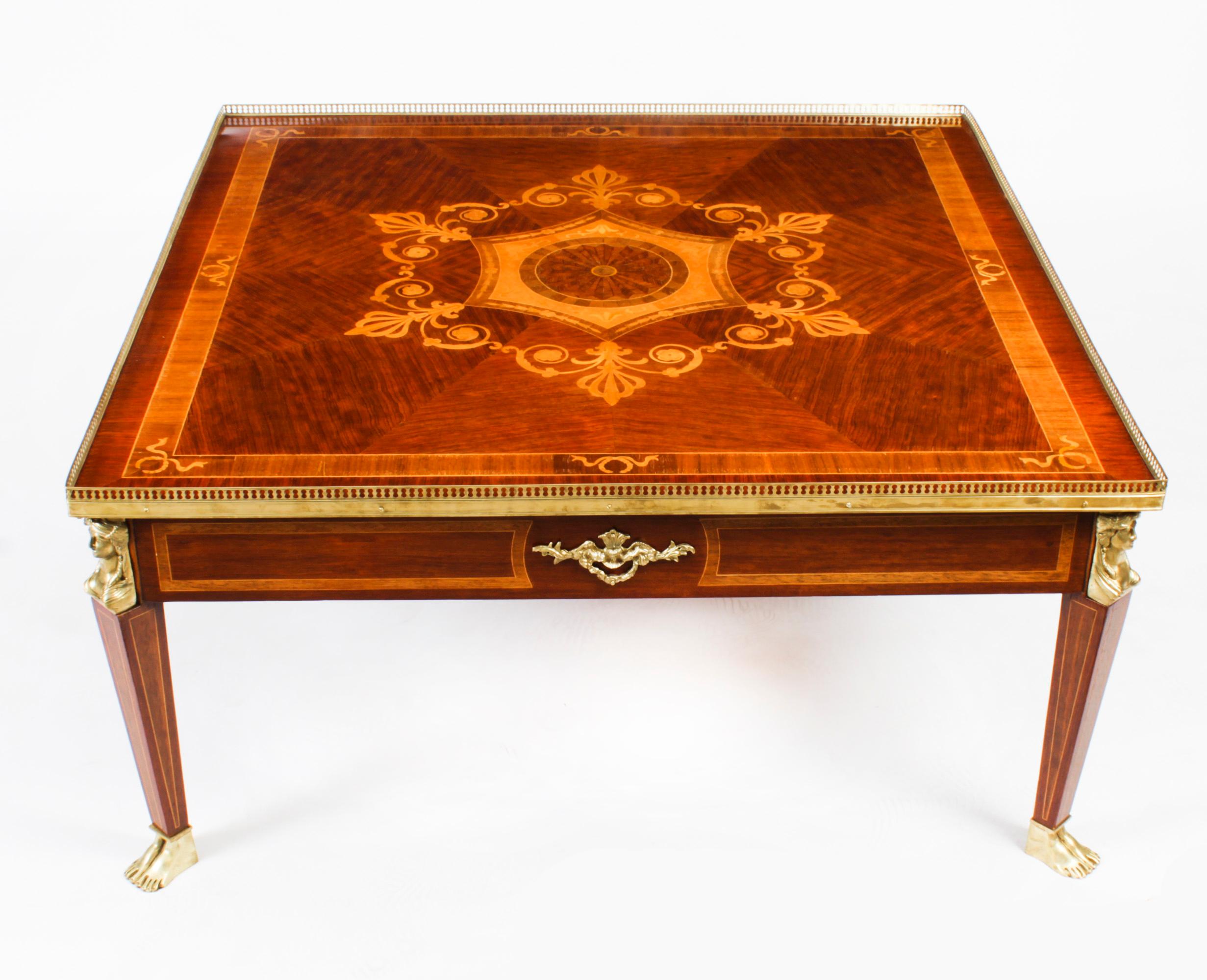 This is a stunning Vintage walnut and marquetry inlaid French coffee table, in the elegant Empire style, with fabulous decorative ormolu mounts, dating from the last quarter of the 20th century.

It has stunning ormolu decoration with mounts,