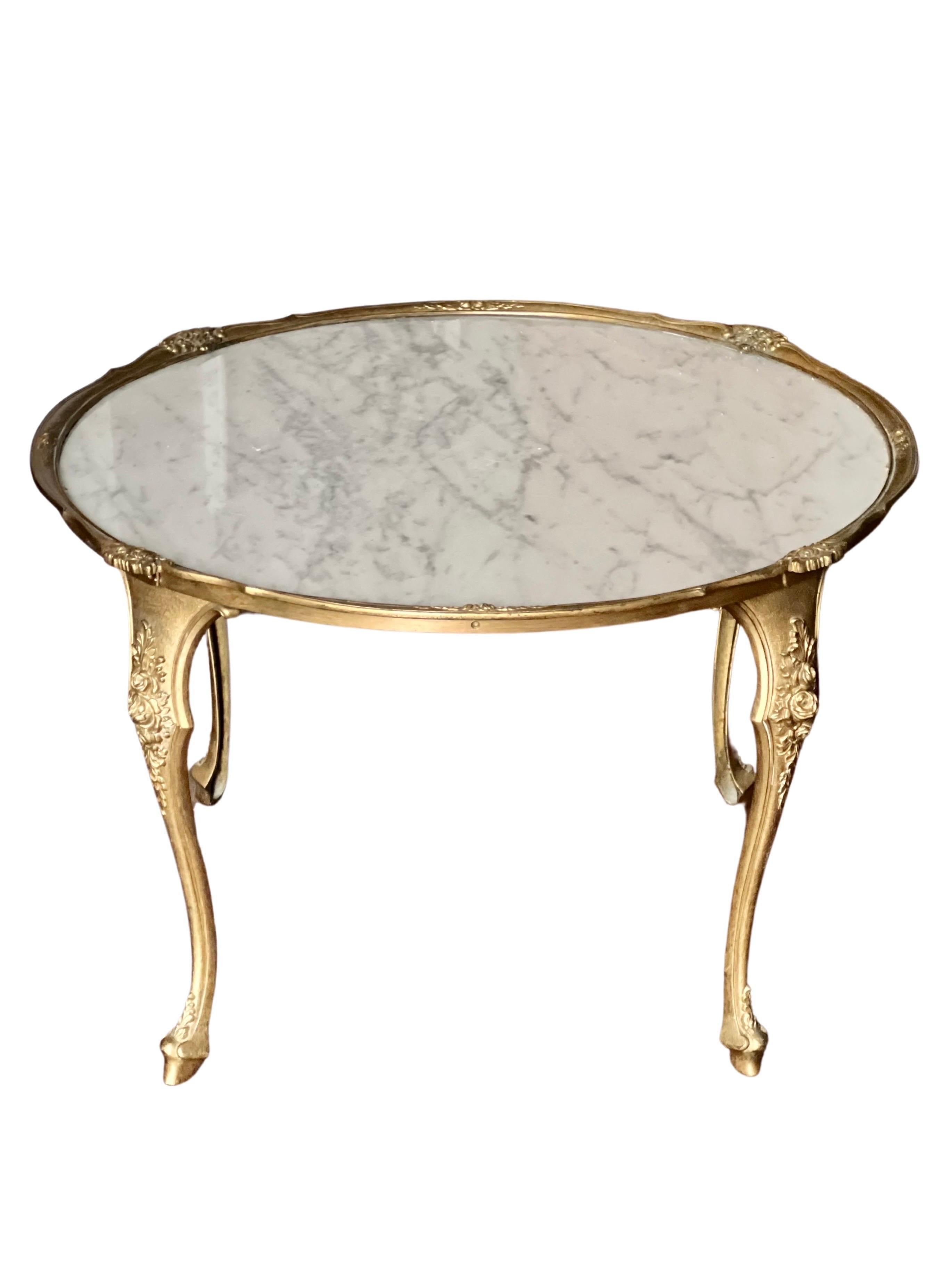 Vintage French Empire solid brass and Carrara marble coffee, cocktail or side table, France, c. 1930's.

This petite, elegant table is beautifully adorned with delicate floral motifs throughout and graceful cabriole legs. The inset marble top is