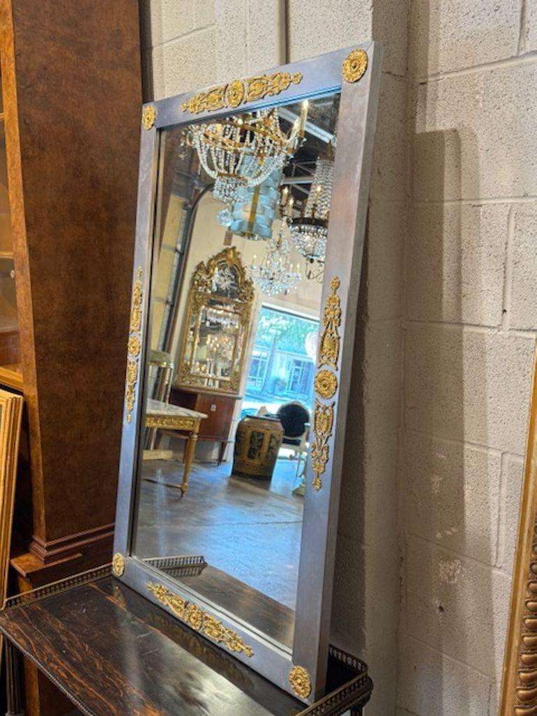 Lo specchio Vintage French Empire in acciaio e ottone è un pezzo unico ed elegante che emana un senso di lusso e raffinatezza. Questo originale specchio presenta intricati dettagli in acciaio e ottone che aggiungono un tocco di fascino lucido a