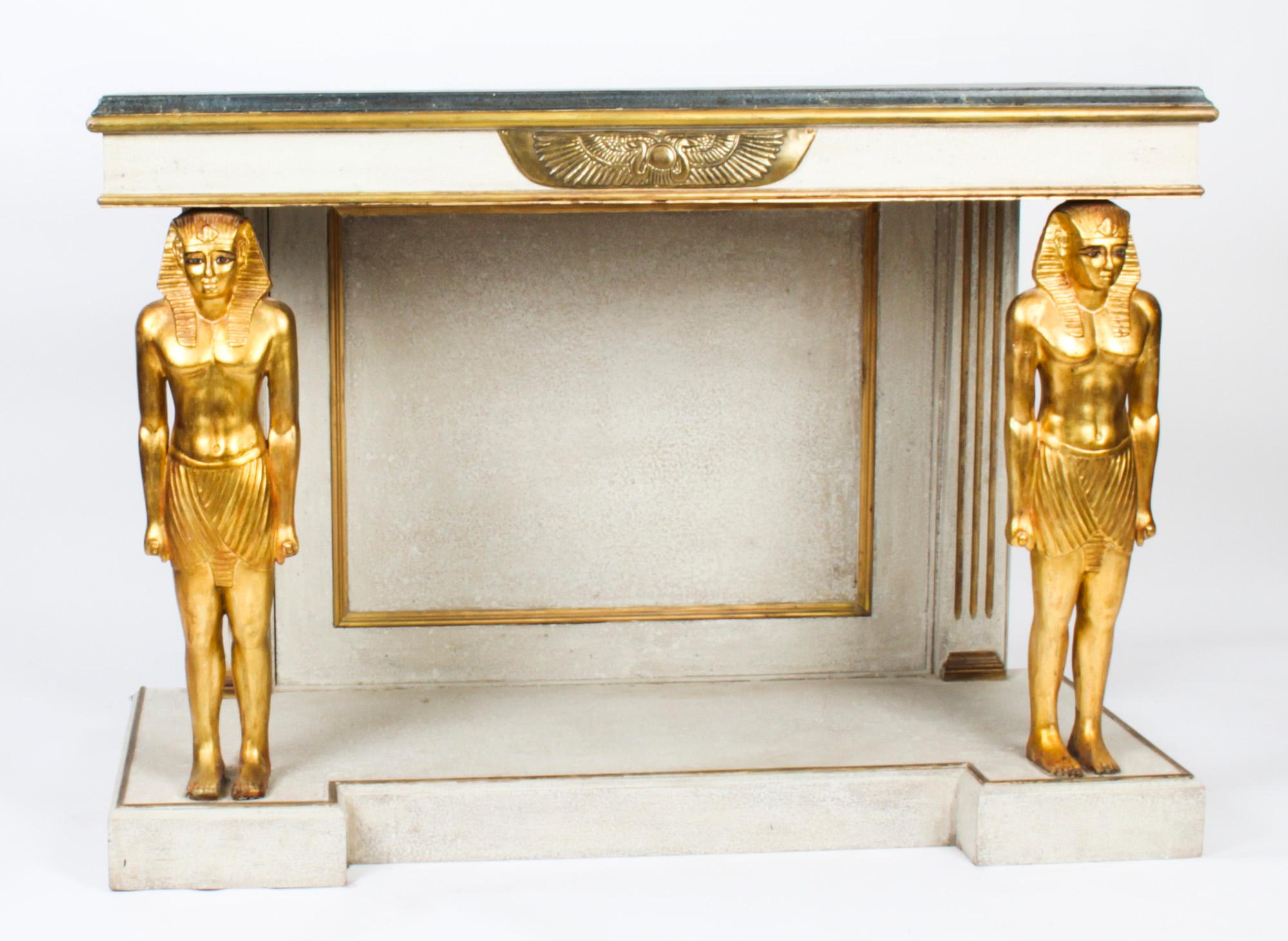 This is a beautiful vintage French Empire style painted gilded and ormolu mounted console table, Mid 20th century in date.

The rectangular faux marble top with an ormolu plaque to the frieze above a pair of classical carved gilt Egyptian pharaoh