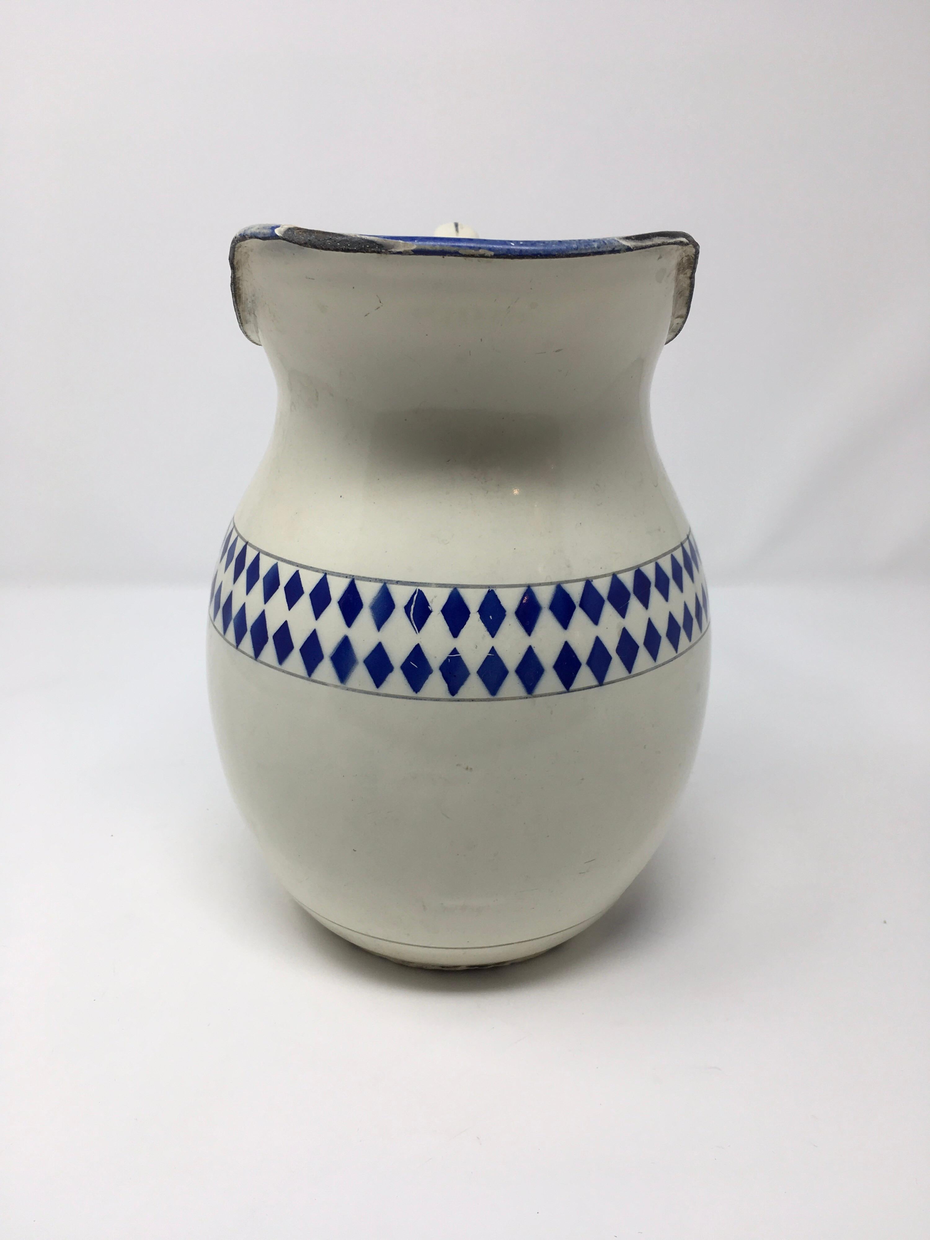 This is a vintage blue and white enamel French pitcher. With the beautiful diamond blue pattern we imagine it filled with sunflowers for a tabletop centerpiece. The pitcher is stabile to hold water as the missing enamel is only on the exterior, the