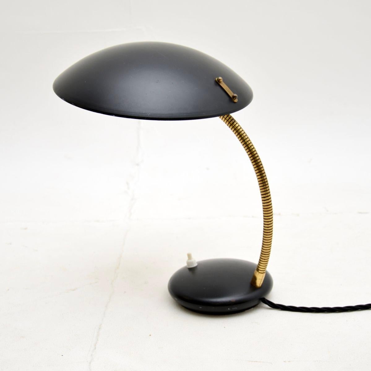 A wonderful vintage French enameled tole and brass desk lamp. This was recently imported from France, it dates from the 1960-70’s.

It is of superb quality, the shade and base are black enameled tole and are held together by an articulated brass