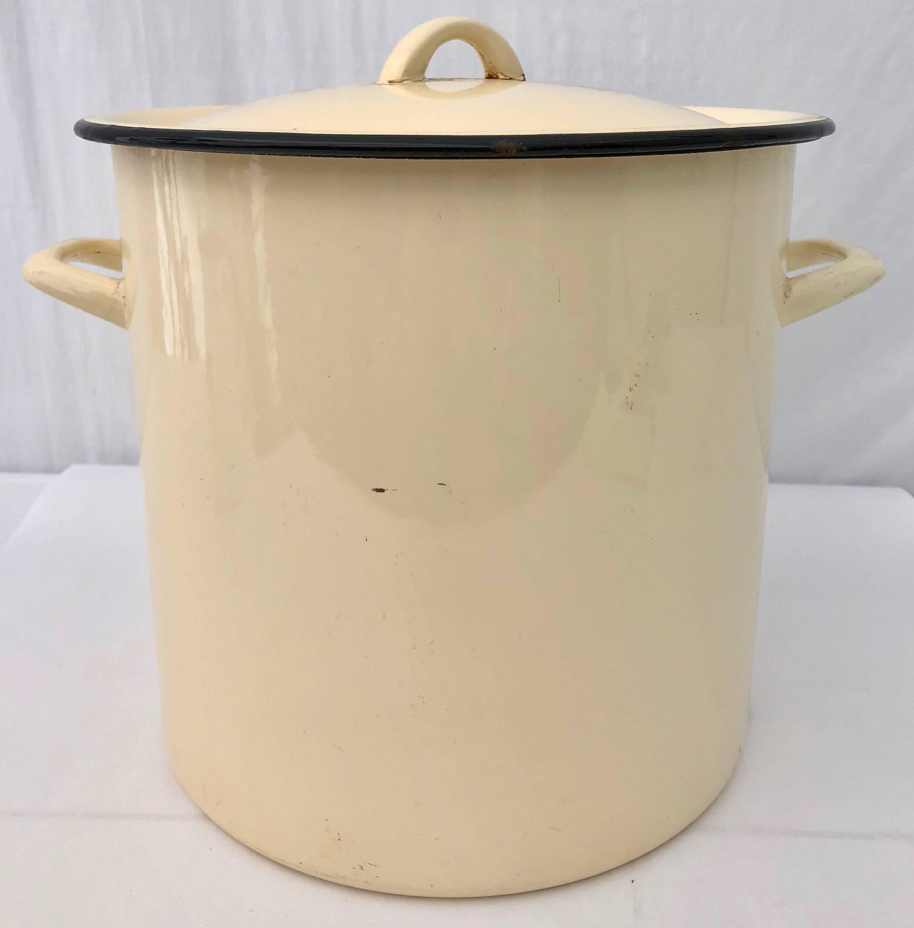 This is a great French enamelware large yellow pot with its original black trimmed lid. It would be beautiful filled with fresh or dried flowers or used in a bathroom to discretely store extra toilet paper or for a party, filled with ice to chill