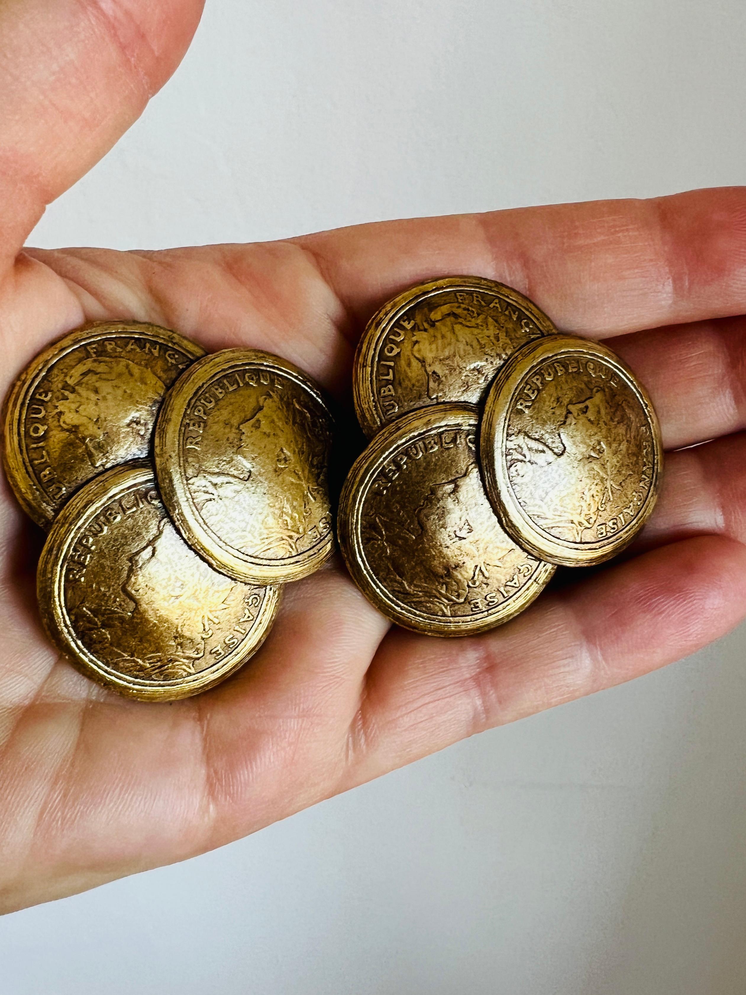 Vintage French-inspired coin clip-on earrings featuring layered designs resembling 19th-century French République coinage. These unique earrings showcase a detailed embossed profile surrounded by laurel leaves, adding an elegant historical touch to