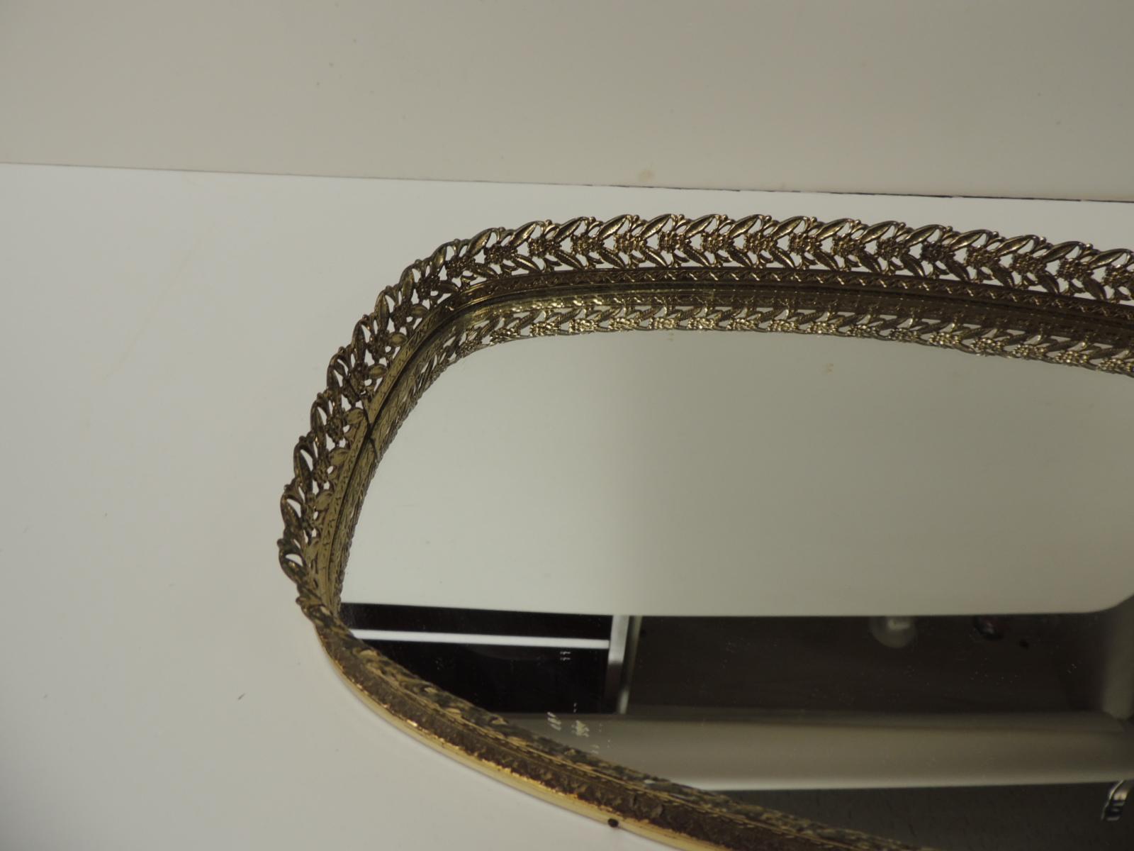 Vieux plateau de courtoisie ovale filigrane avec miroir
Plateau en laiton poli avec bord percé de fleurs et miroir ovale. Soutien du conseil d'administration. 
Français:: 1970
Taille : 14 x 8 x 1::5 
 