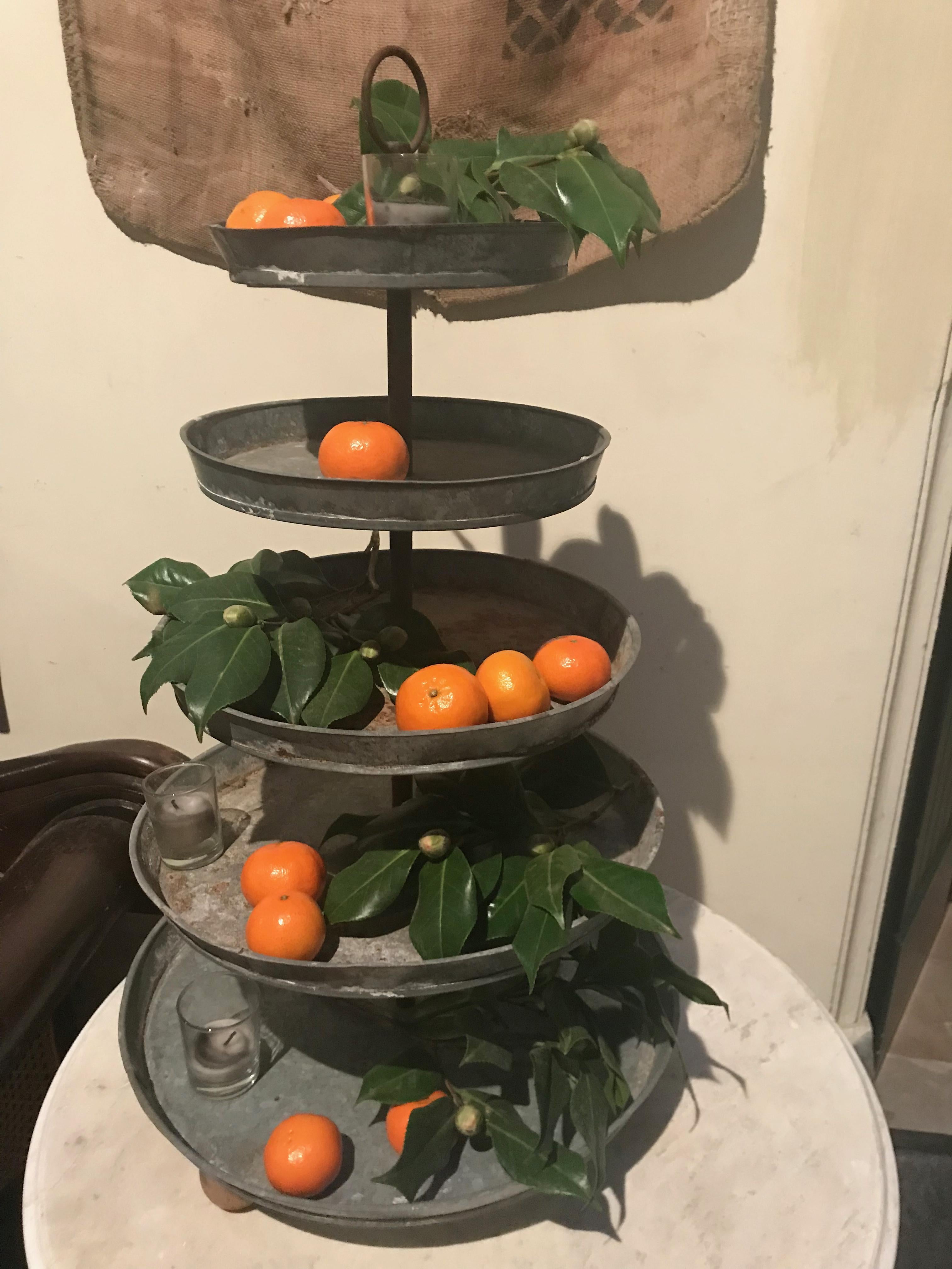 Very decorative French galvanized metal five-tier plant stand centrepiece with iron handle.
This stand was used in a flower shop but it could be filled with cupcakes, potted plants, soaps and oils for the bath, oils and herbs in the kitchen or tea