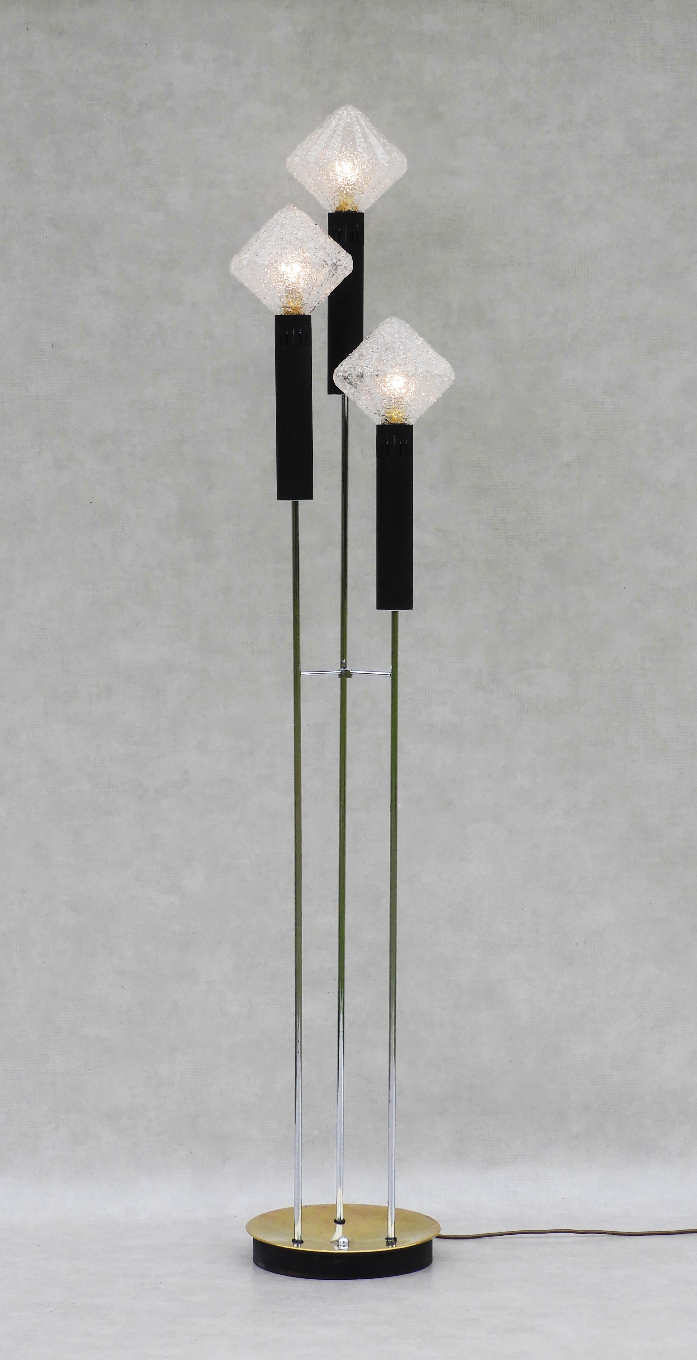 Vintage French floor lamp three light torchère c1970

Mid-century three-light torchère floor lamp from 1970s France.
An unusual trio of pleated granulated glass ‘buds’ on matt black and chrome ‘stems’ supported by a circular brass plate and heavy