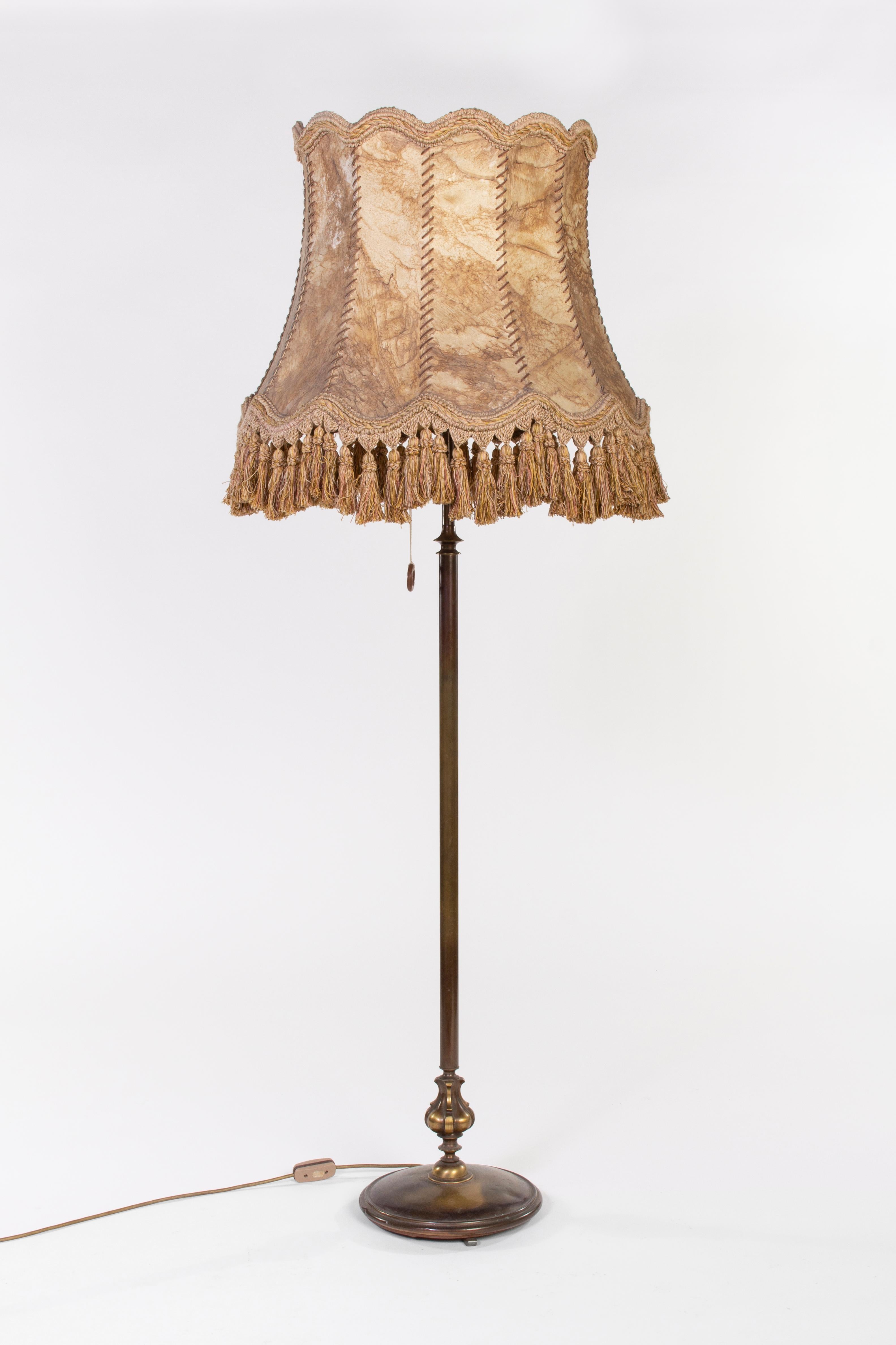 Vieille lampe sur pied de France avec abat-jour en cuir beige, décoration en laiton et base en cuivre. La lampe est en parfait état.
