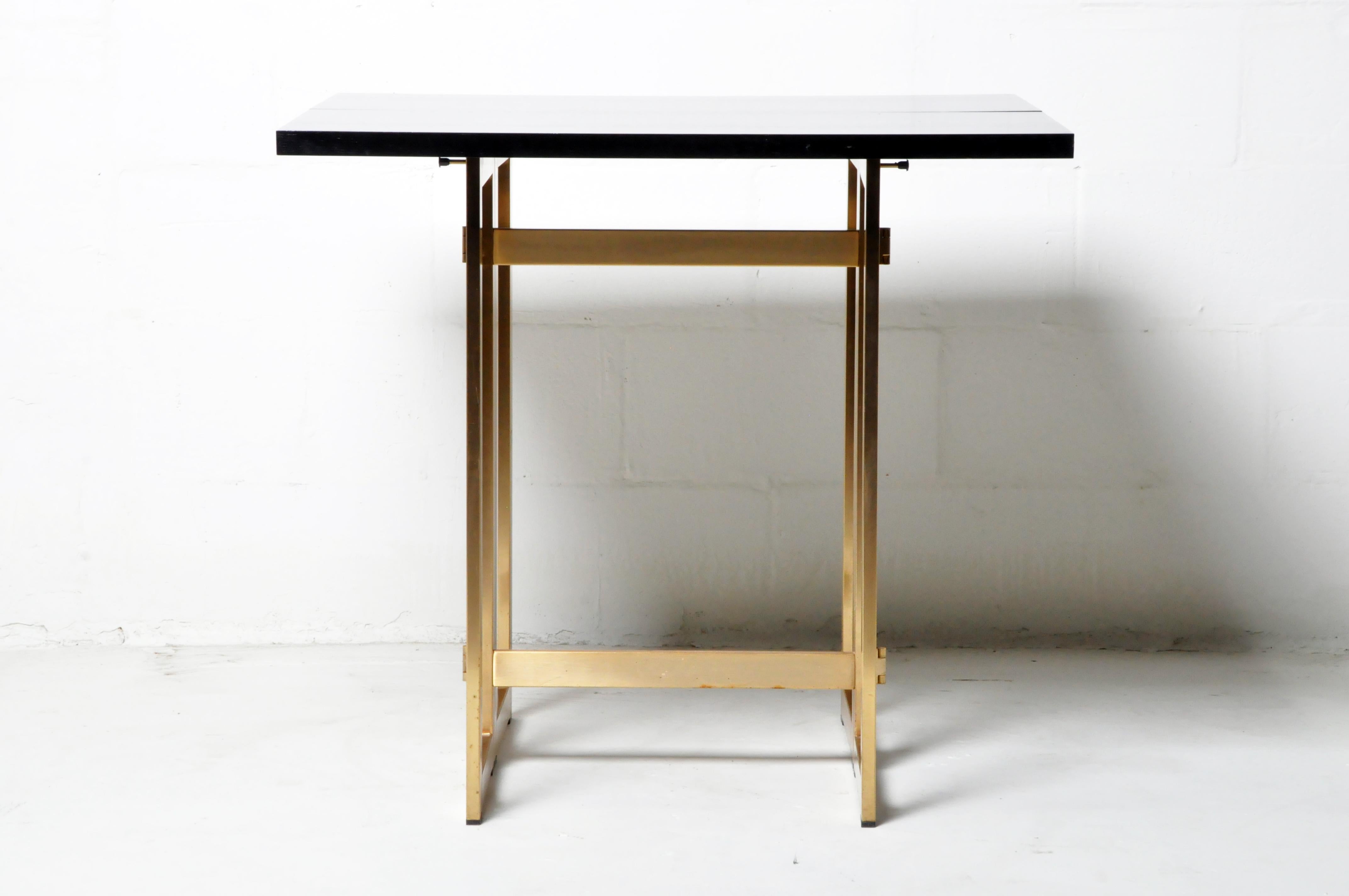 This vintage folding console table is from Paris, France and was made from oak veneer and brass legs, circa 20th century. The table features folding legs and top as seen in the photos. Wear consistent with age and use.
      