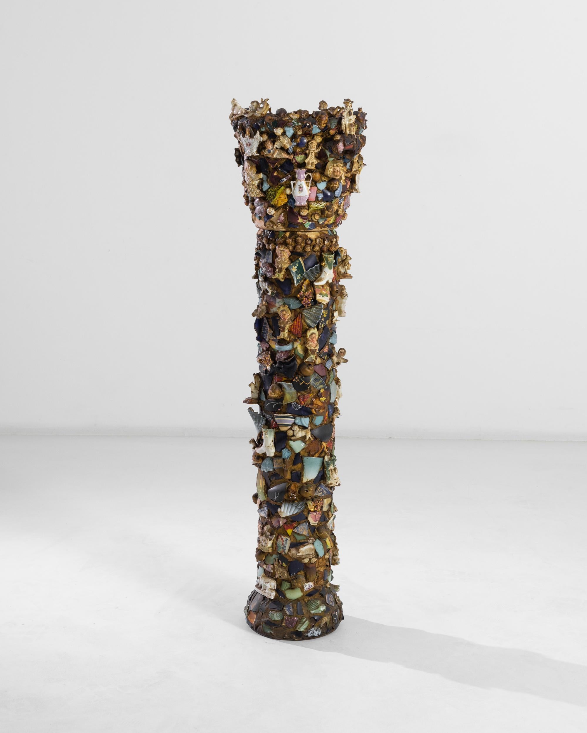 A 20th century column created in France, this two part piece consists of a vase standing atop a pedestal. An ode to the gleaning practice, the piece gathers an impressive amount of miscellaneous items, among which detailed figurines, shells and
