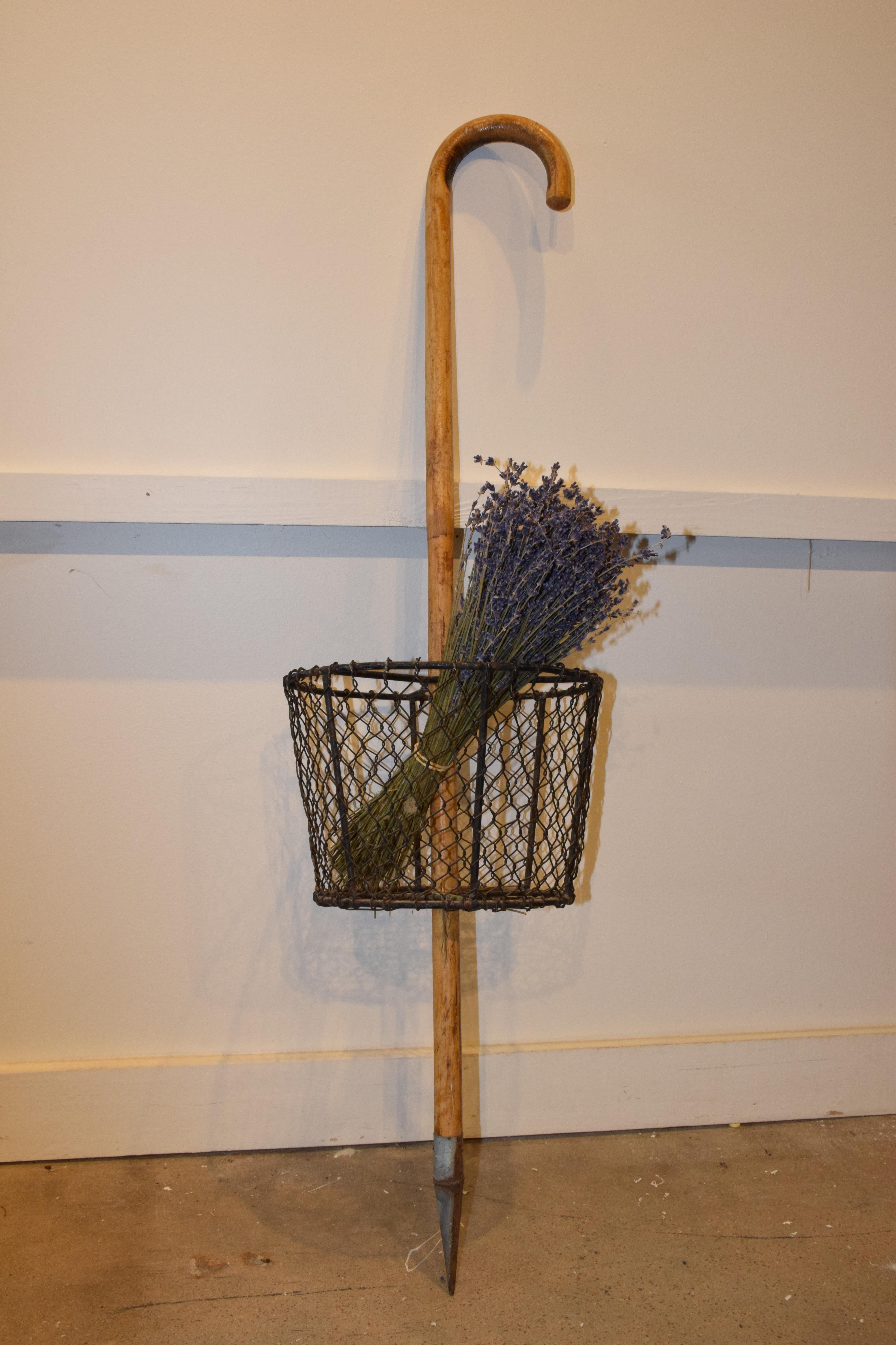 This vintage French gathering basket and cane will be a wonderful addition to your gardening hobbies. The wire basket is attached to a wood cane center which has a pointed metal tip on the end. The cane can be used for support while walking. The