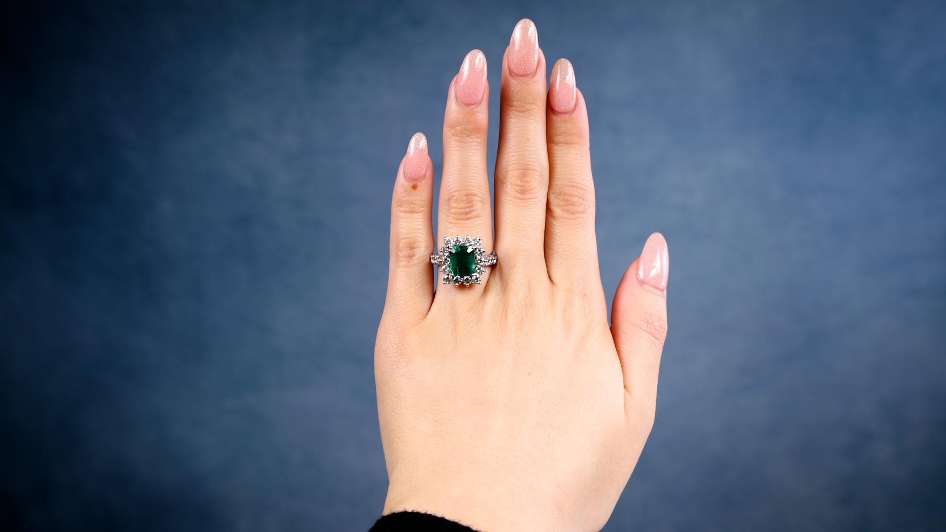 One Vintage French GIA Zambian Emerald Diamond 18k White Gold Ring. Featuring one GIA octagonal step cut emerald weighing approximately 2.10 carats, accompanied by GIA #5231183429 stating the emerald is of Zambian origin. Accented by 20 round
