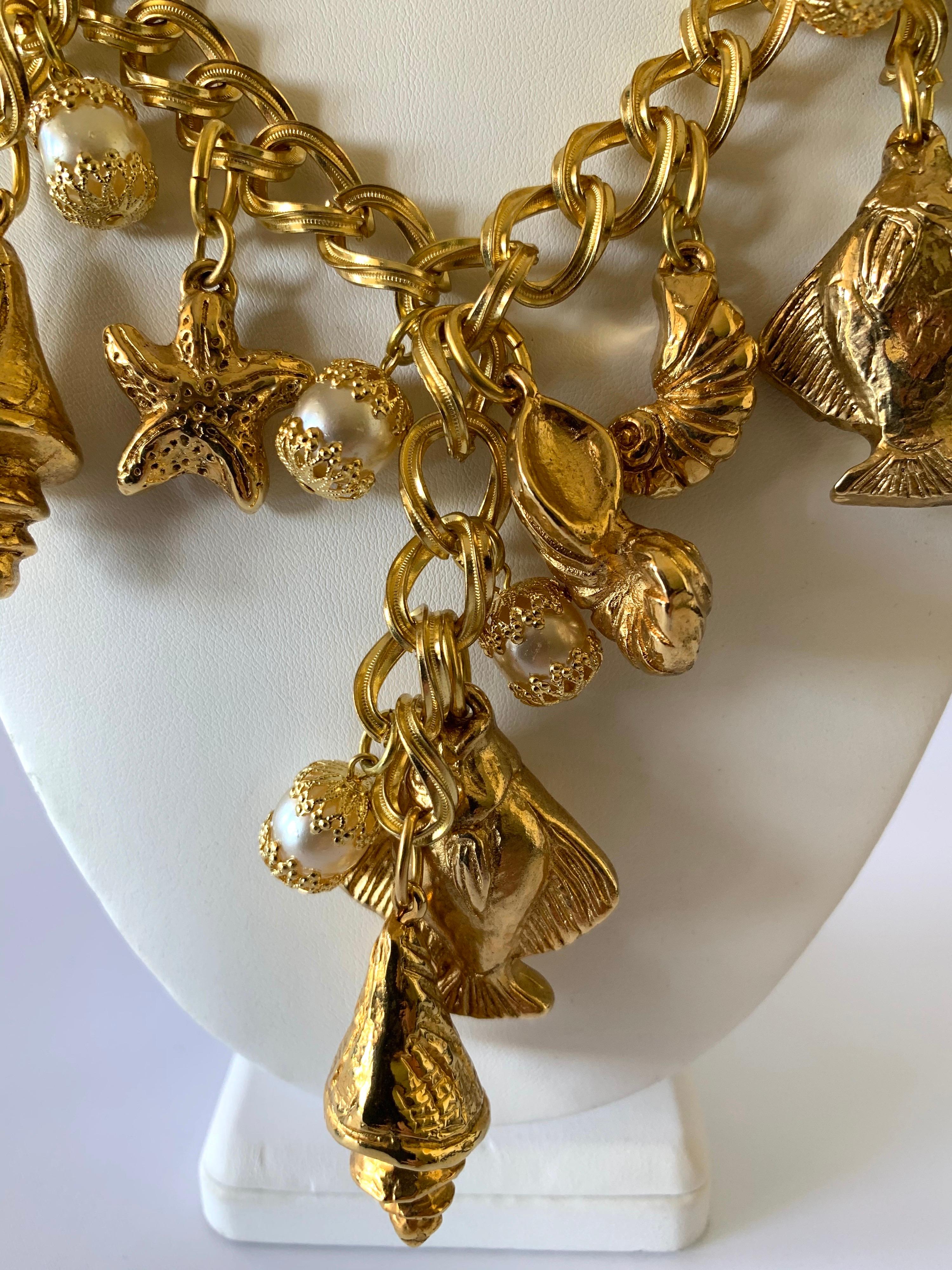 Vintage French nautical charm necklace, comprised out of a thick gilt metal chain adorned by a plethora of fish, seashells, and pearls circa 1980 by Chantal de Kerouartz. The necklace is also featured in the August issue of Vogue Spain.