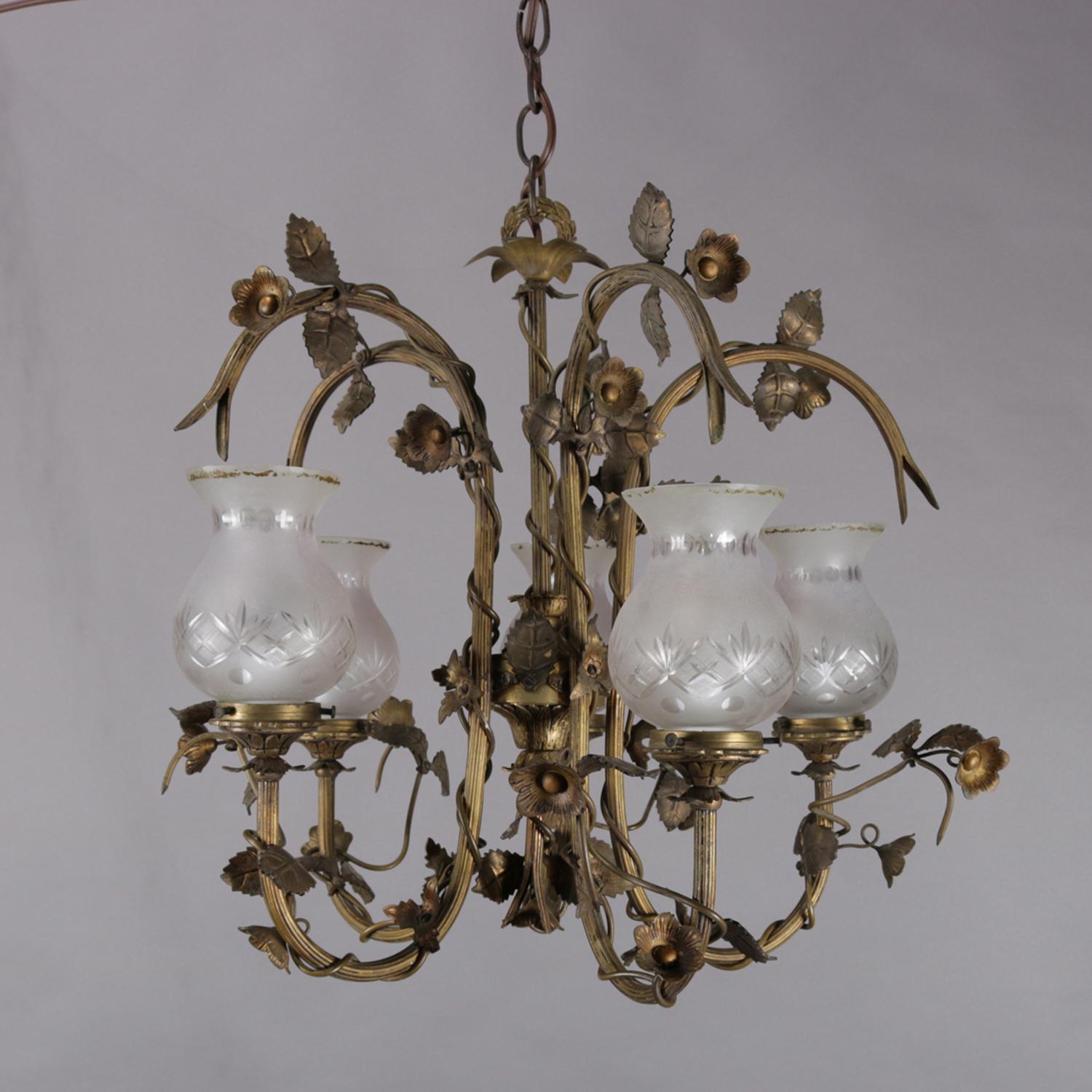 Vintage French style chandelier features gilt metal frame with five C-scroll arms wrapped in floral and vine 
terminating in lights with cut glass frosted shades, circa 1940.

Measures: 18