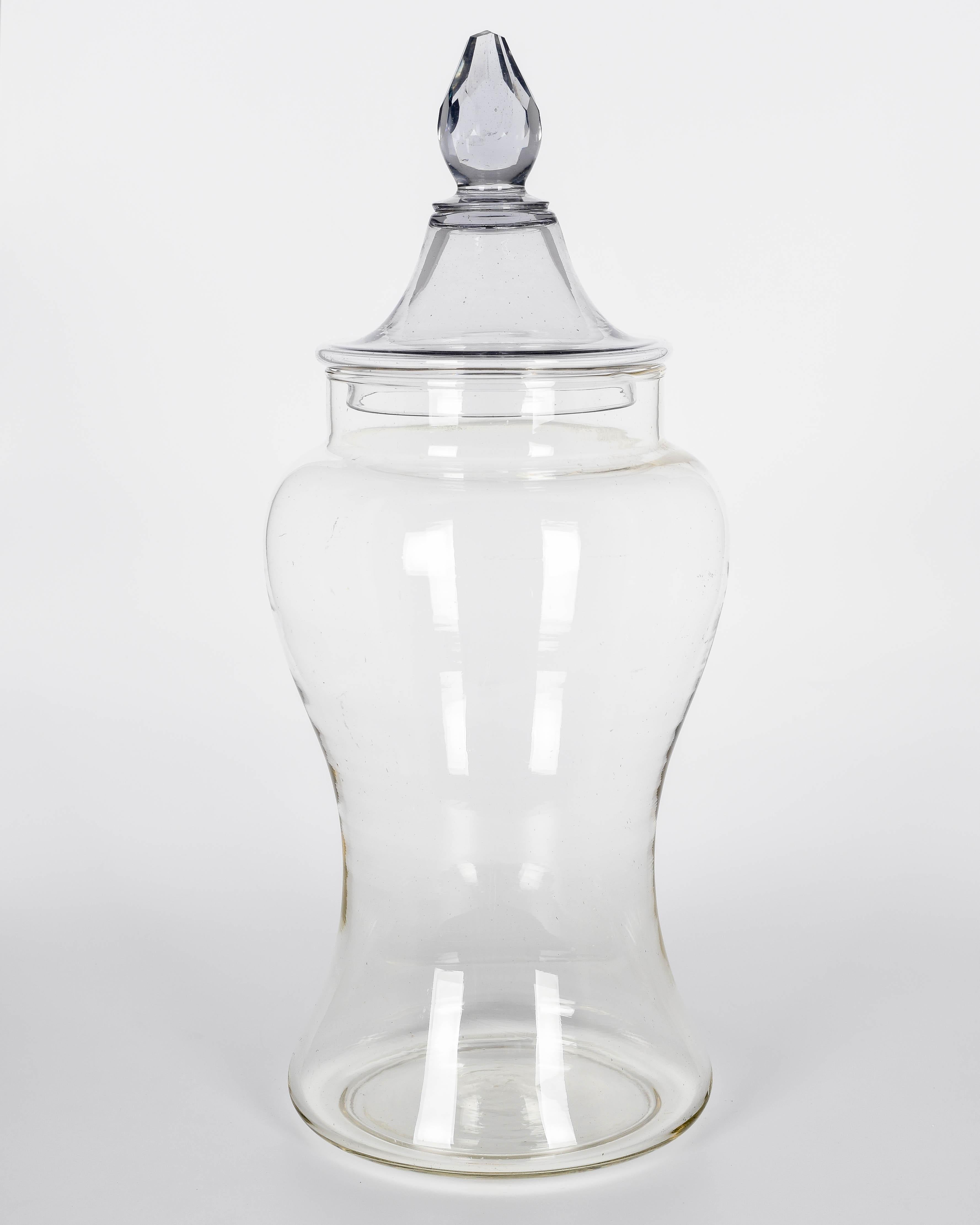 A French glass lidded apothecary or candy jar. Urn shaped faceted form. Lid with faceted cut glass knob. In good condition for the age and use, with light scratches and fleabite chip to knob. Purchased from a confiserie, or sweet shop, along many