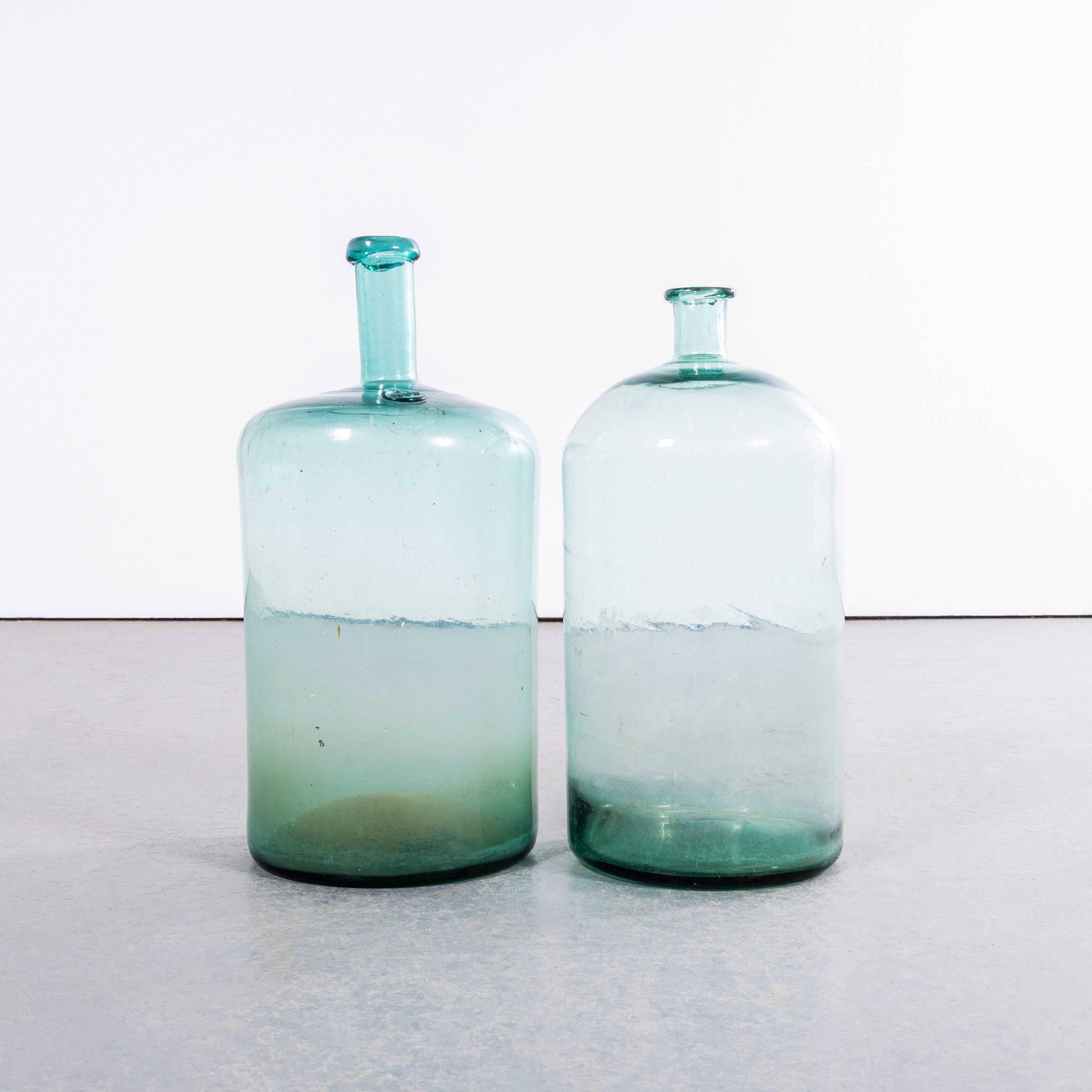 Damigiane francesi d'epoca in vetro verde - Coppia. 

Una coppia di damigiane in vetro soffiato a bocca utilizzate come contenitori tradizionali principalmente per la conservazione e il trasporto del vino. Queste damigiane sono state pulite con