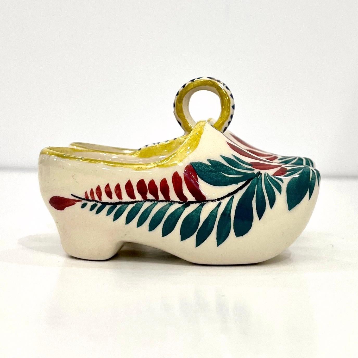 A charming handcrafted decorative salt and pepper holder in the shape of traditional Breton sabot clogs, mid-20th century French pottery majolica, in extremely good condition, signed HB Caen known for this distinctive faience pottery, characterized