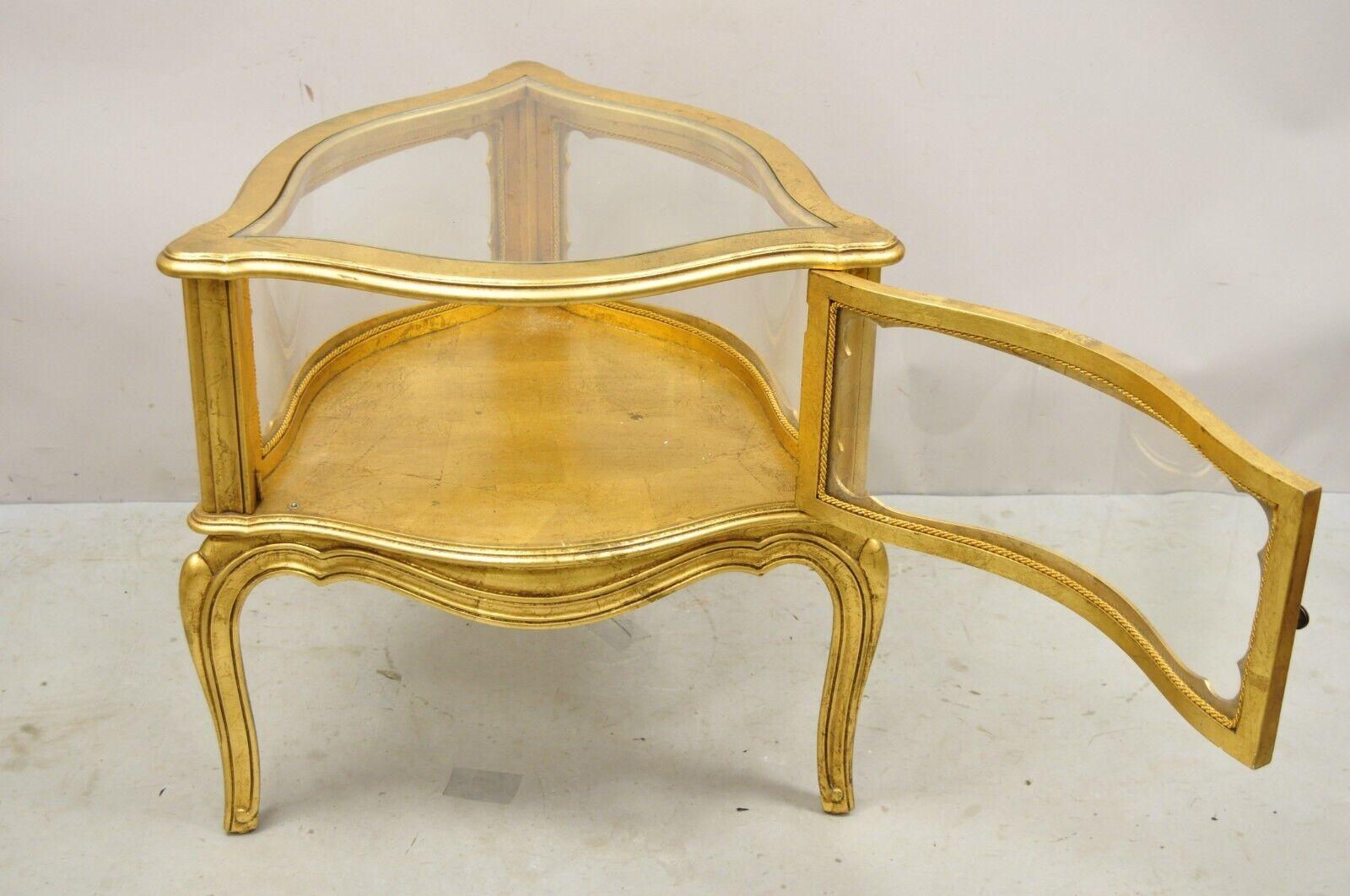 Vintage French Hollywood Regency Gold Giltwood Triangular Display Cabinet Table. Item features 1 swing door, glass top and sides, distressed gold gilt finish, bowed glass sides, great style and form. Circa Mid 20th Century. Measurements: 24