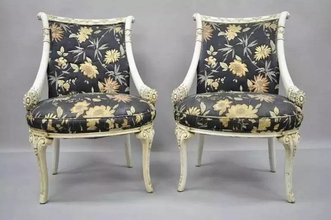 Paire de chaises Cornucopia sculptées d'après Grosfeld House. Cet article se caractérise par des accoudoirs inclinés en forme de corne d'abondance, des pieds sculptés et fuselés, une finition peinte en blanc vieilli et des cadres sculptés de